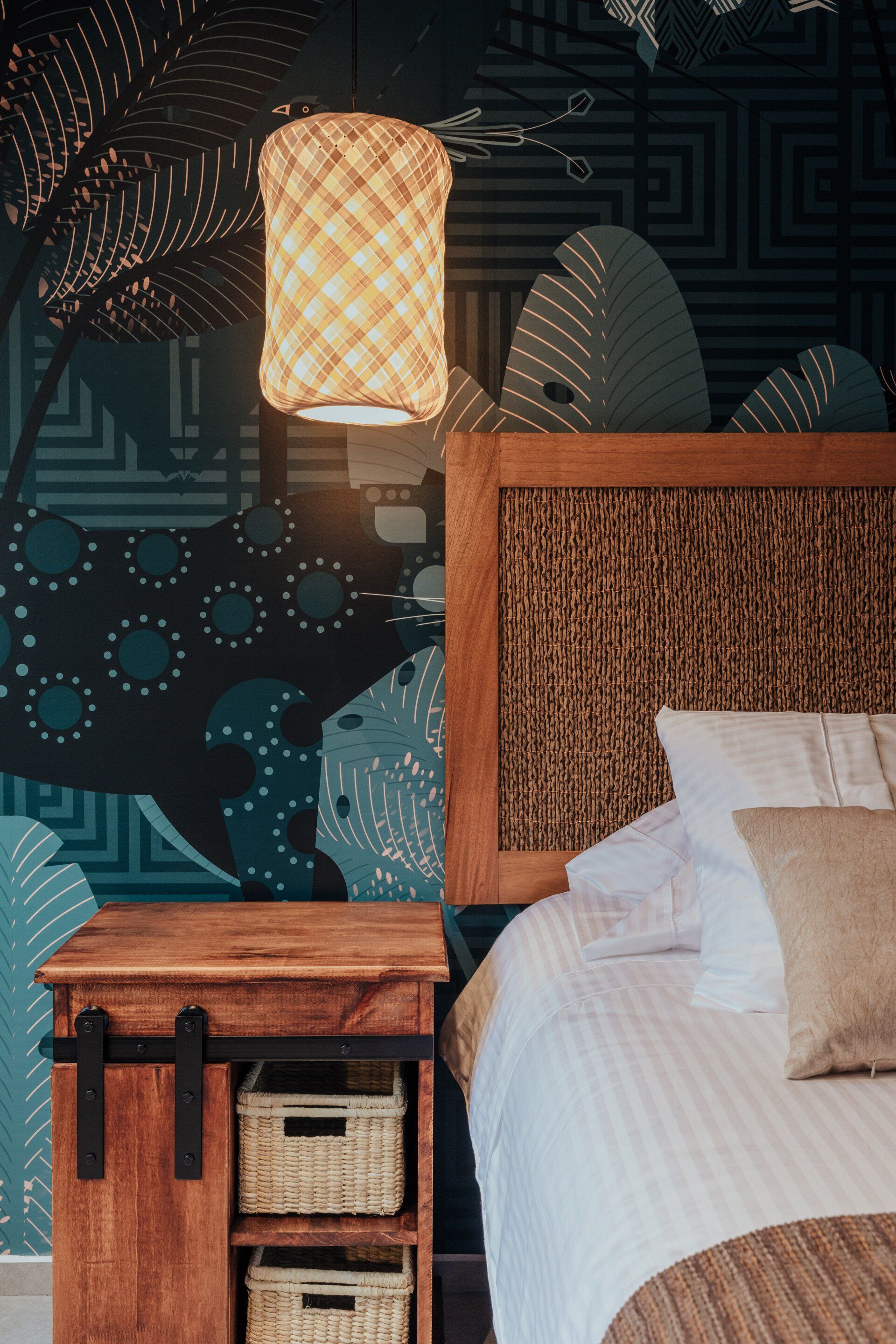 Un dormitorio con una cama, mesita de noche y lámpara.