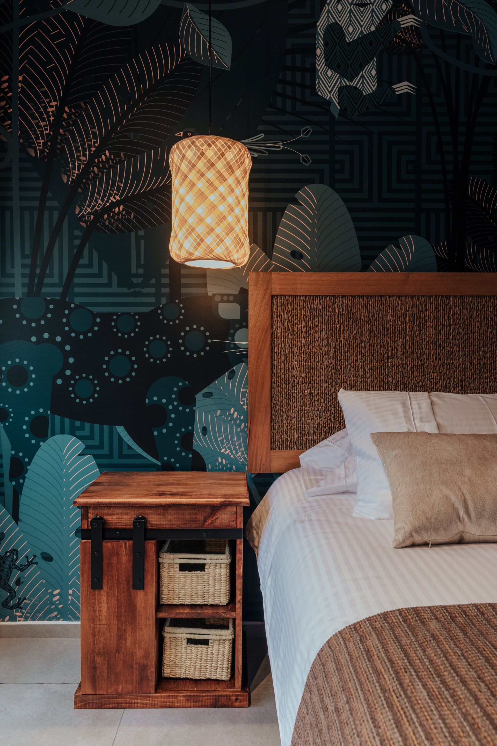 Un dormitorio con una cama, mesita de noche y lámpara.