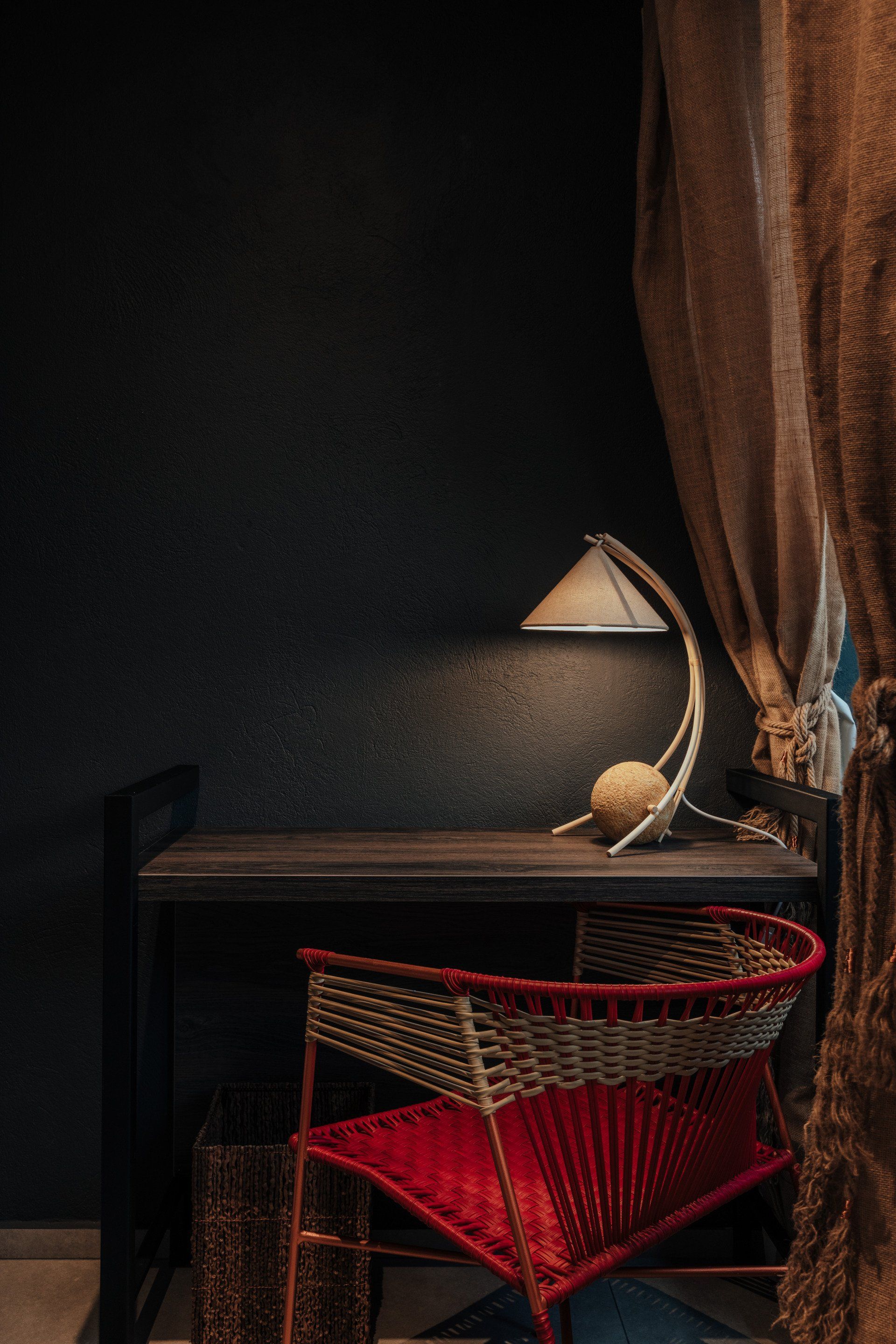 Una silla está al lado de un escritorio con una lámpara encima.