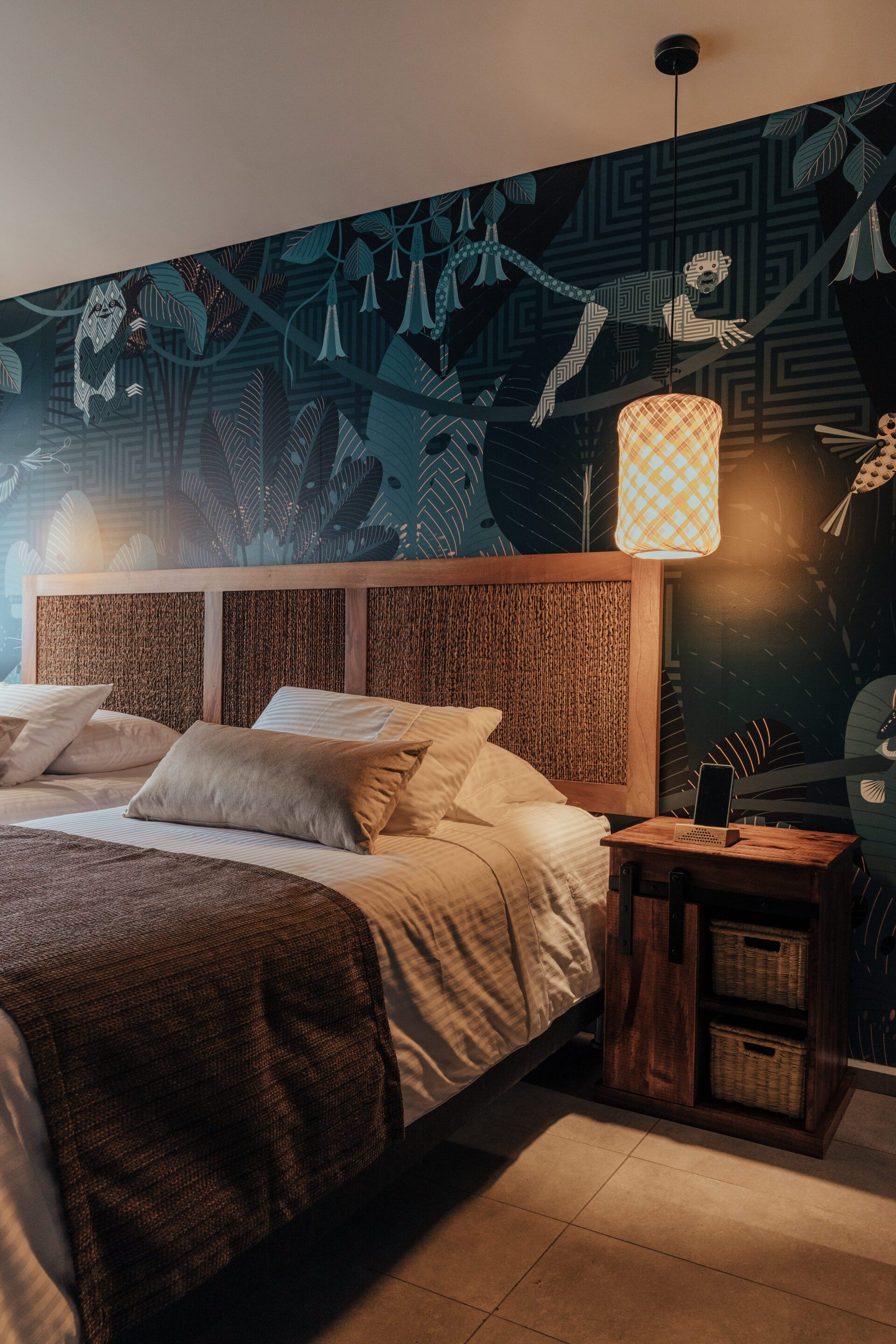 Un dormitorio con una cama, mesita de noche y lámpara.