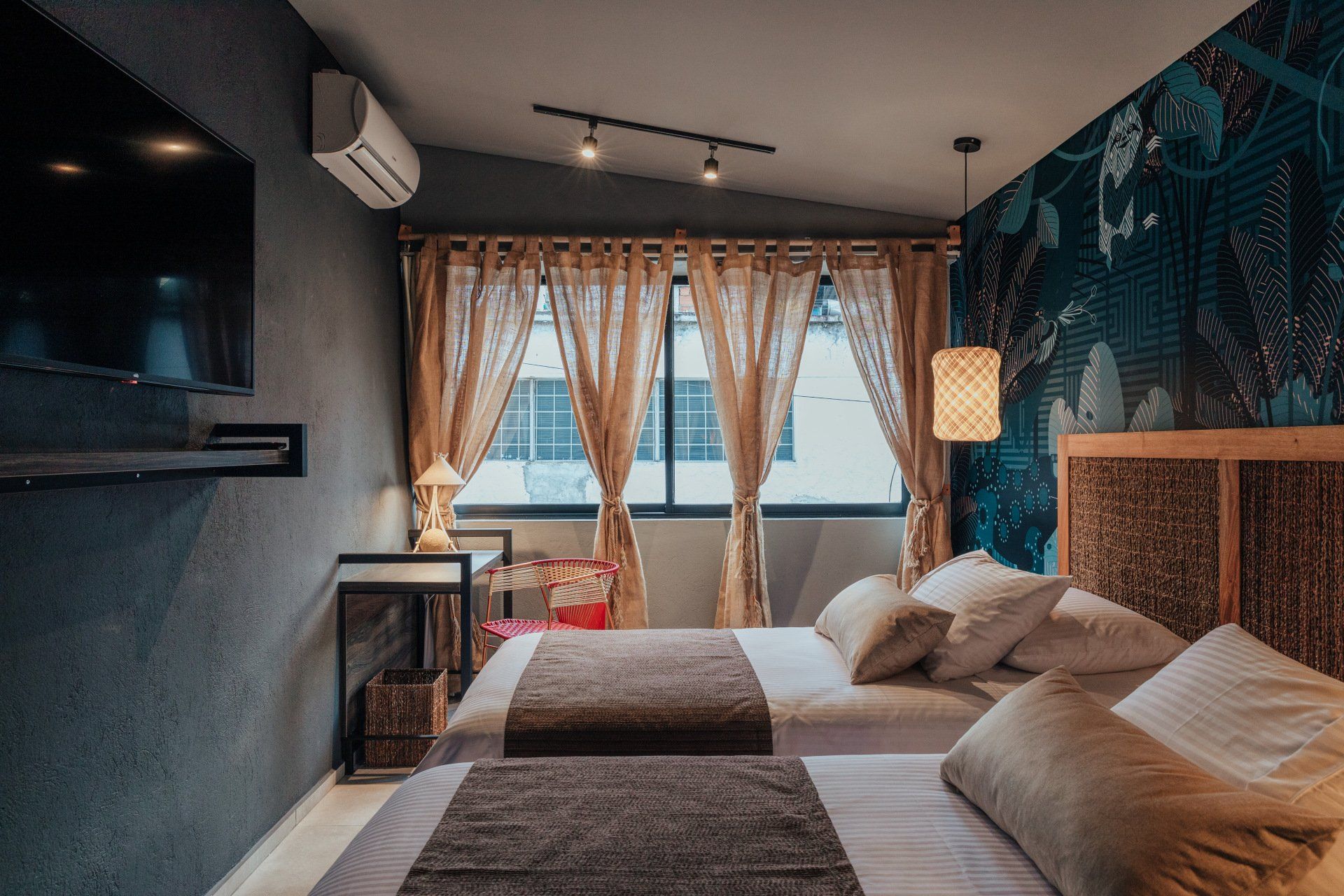 Una habitación de hotel con dos camas y un televisor de pantalla plana.