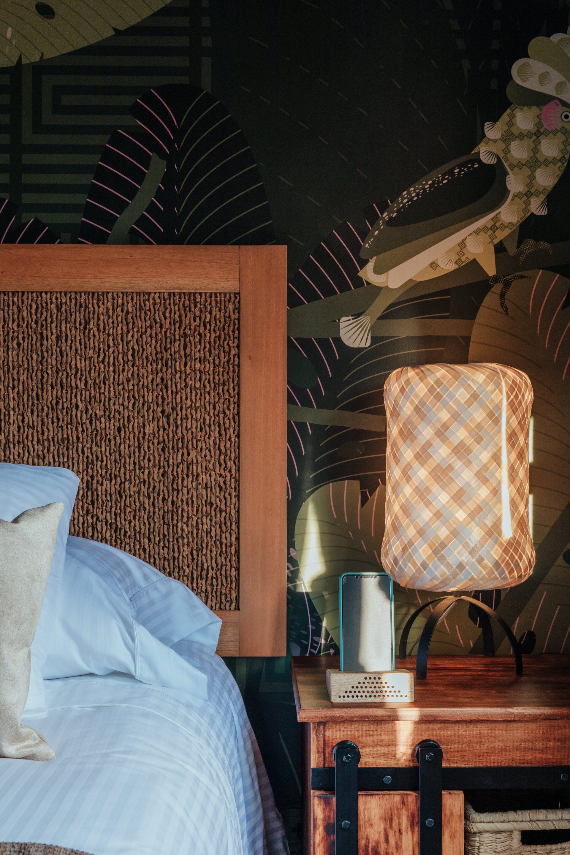 Un dormitorio con una cama y una mesita de noche con una lámpara encima.