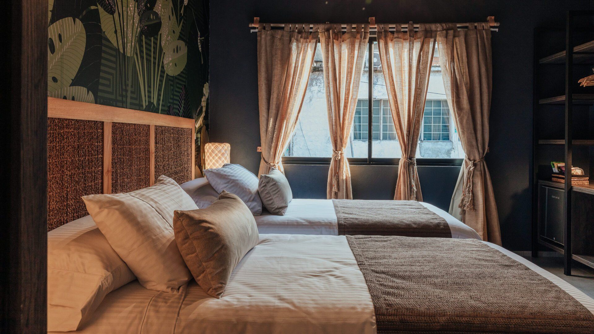 Una habitación de hotel con dos camas y una ventana.