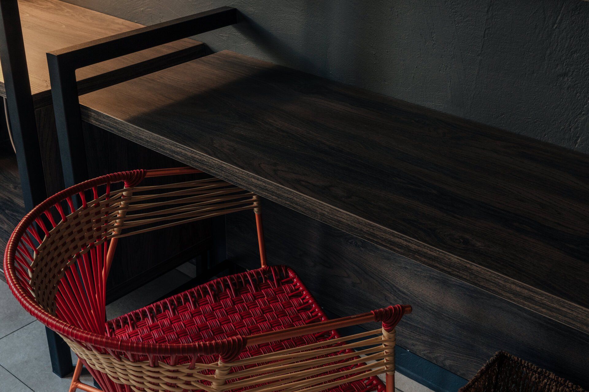 Una silla de mimbre está junto a un banco de madera.