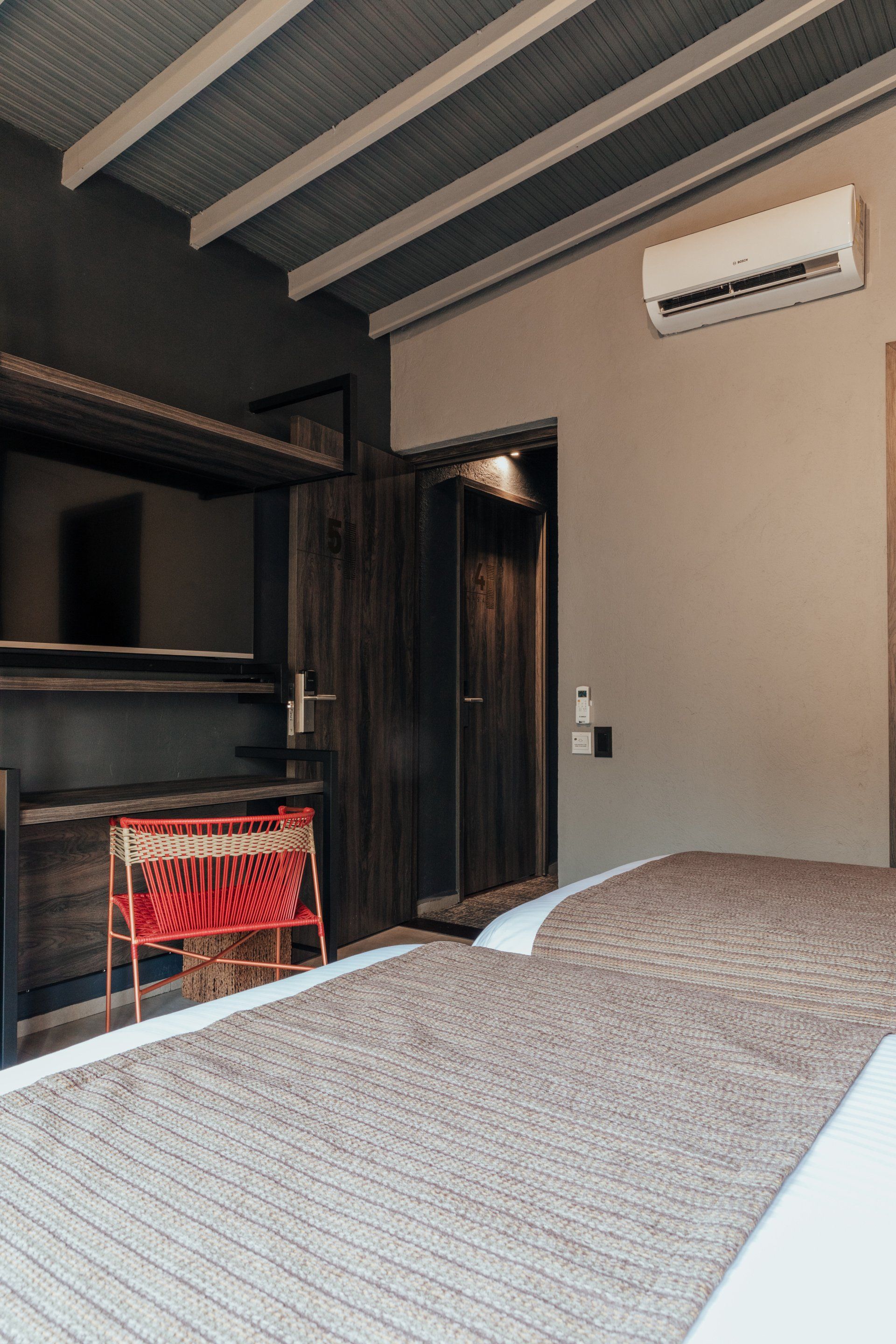 Una habitación de hotel con cama, televisión y aire acondicionado.