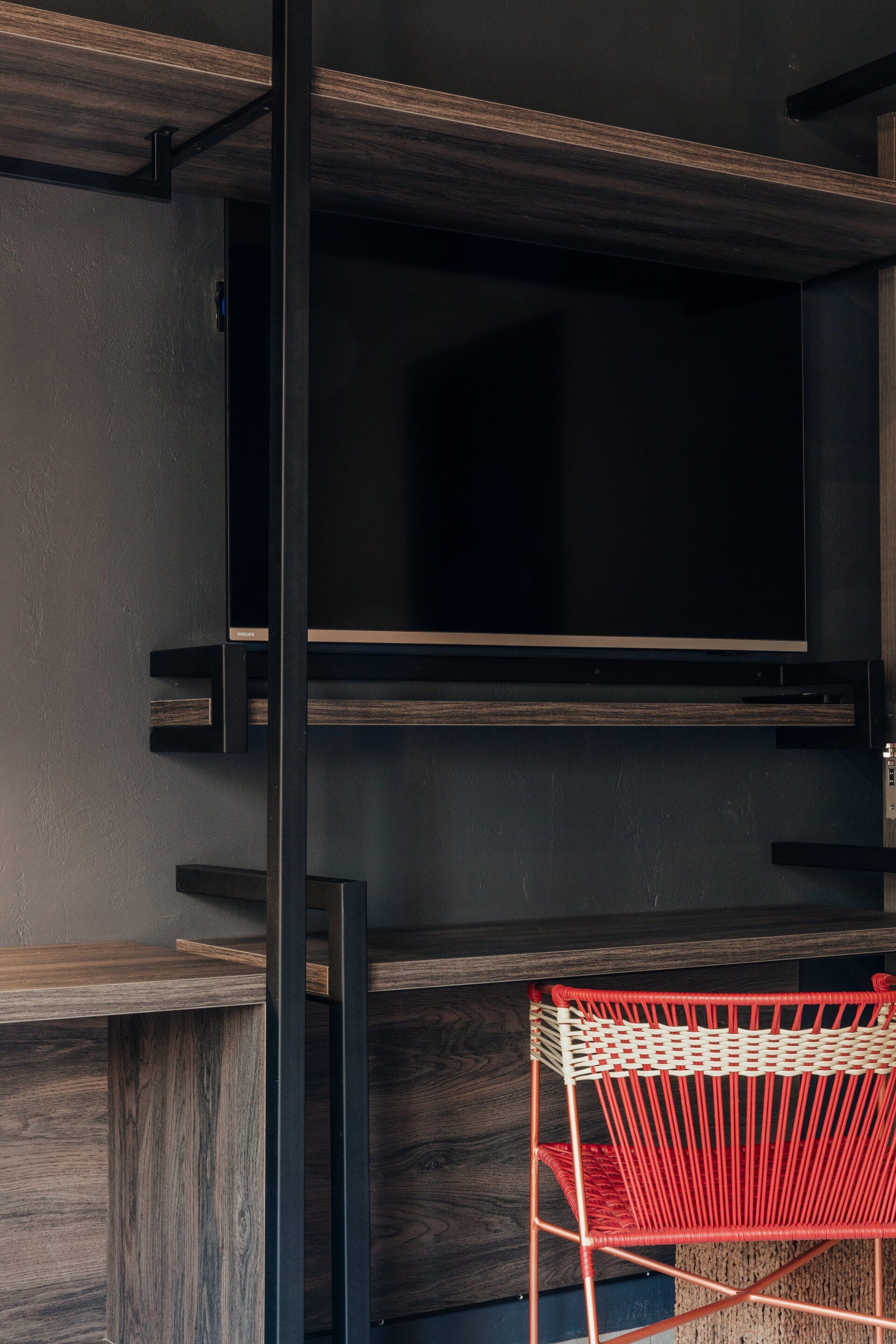 Una silla roja está sentada frente a un televisor en una habitación.