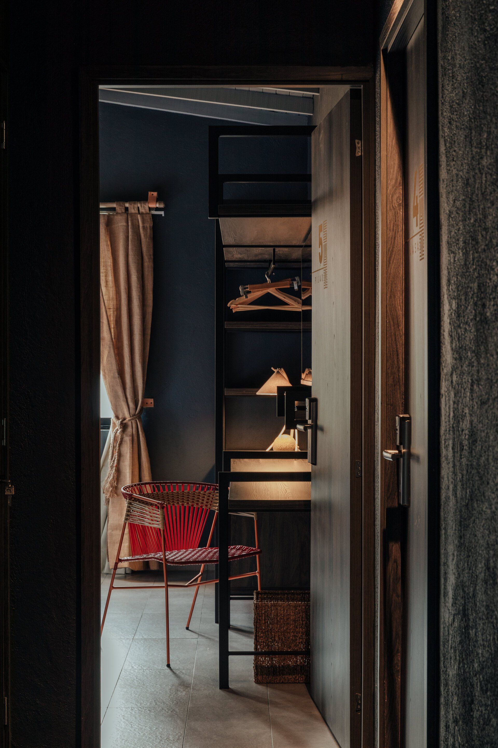 Una puerta que conduce a una habitación con literas y una silla.