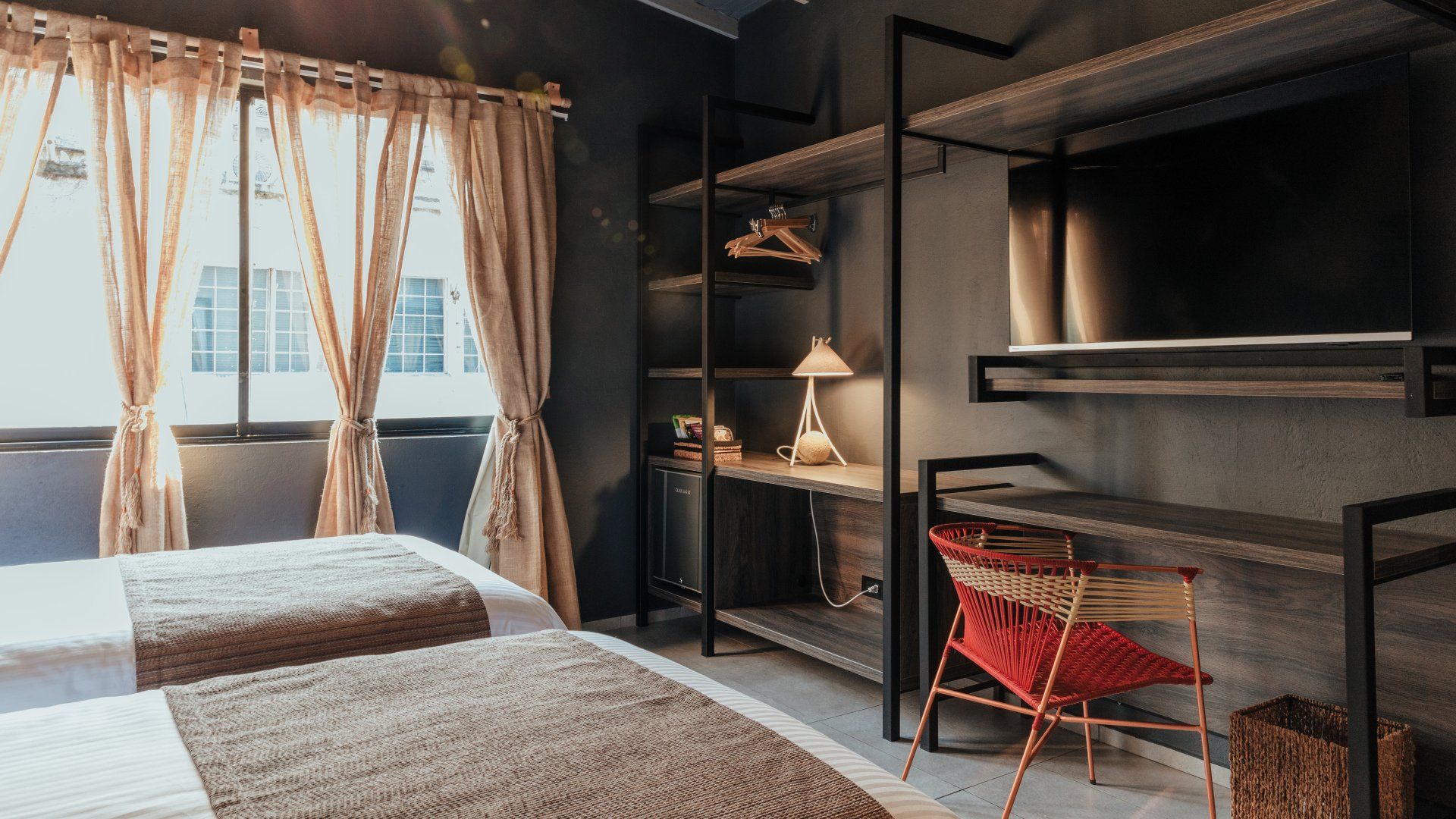 Una habitación de hotel con dos camas, un escritorio y un televisor.