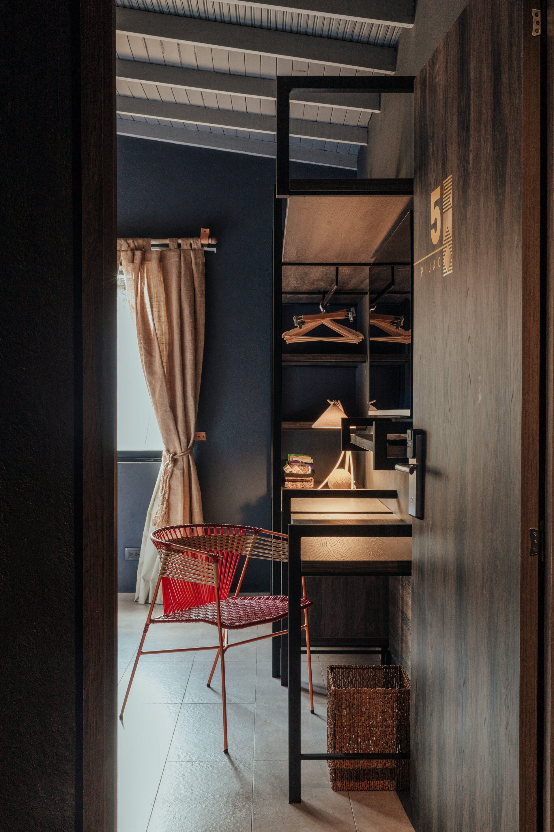 Una puerta que conduce a una habitación con una silla y un escritorio.