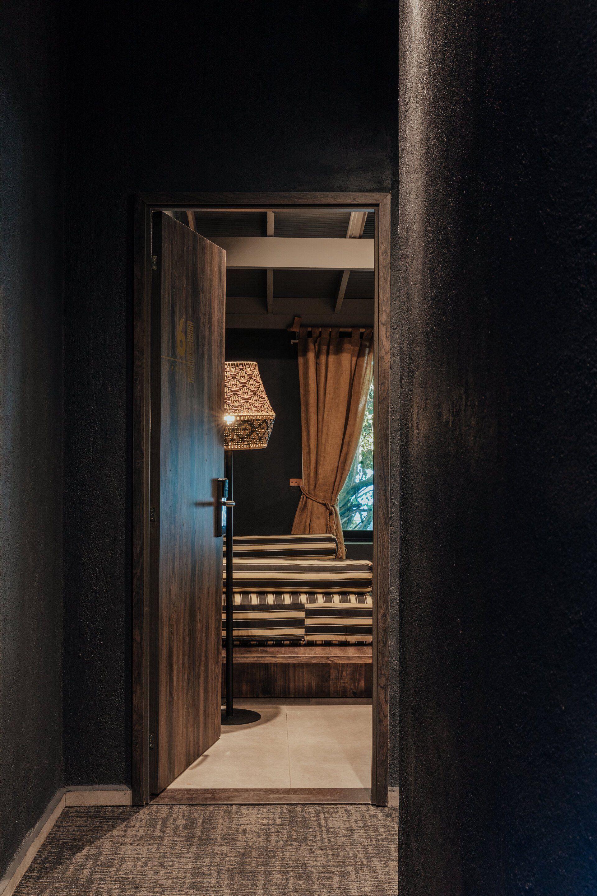 Una puerta que conduce a un dormitorio con una lámpara y una cama.