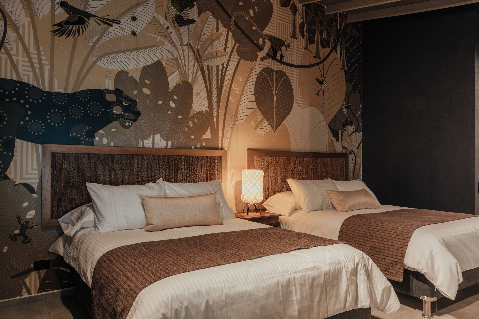 Una habitación de hotel con dos camas y un mural en la pared.