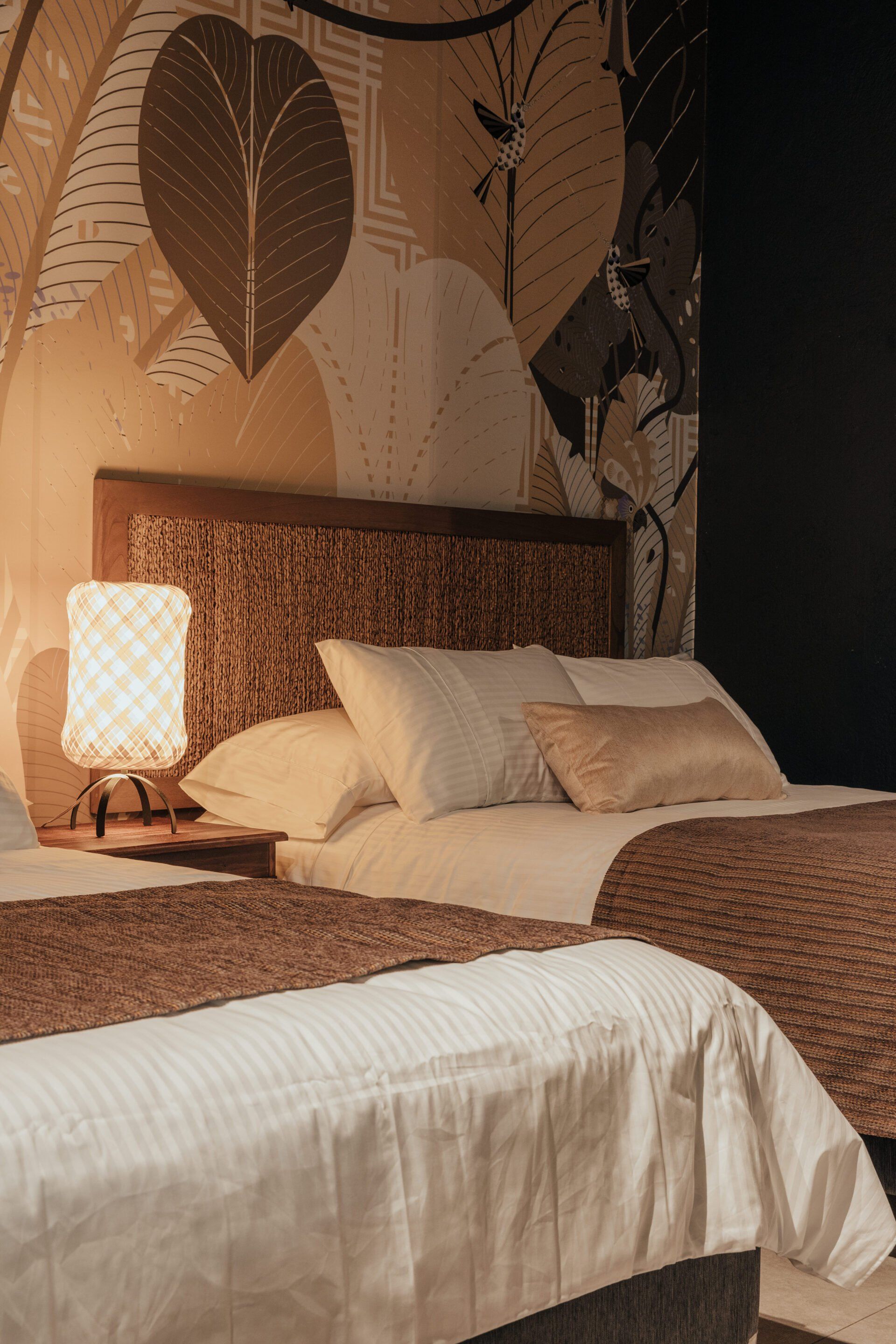 Una habitación de hotel con dos camas y una lámpara.