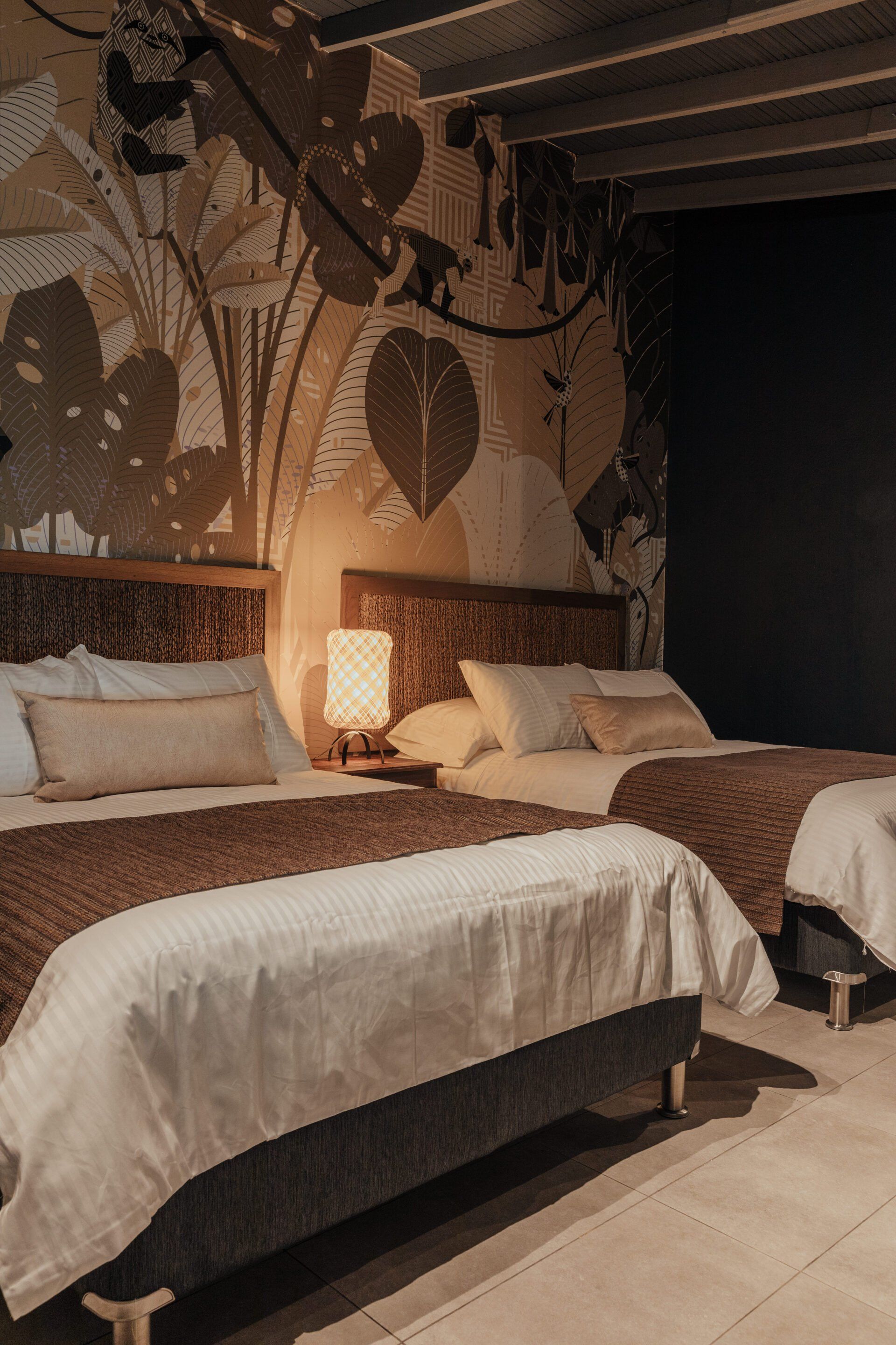 Una habitación de hotel con dos camas y una lámpara.