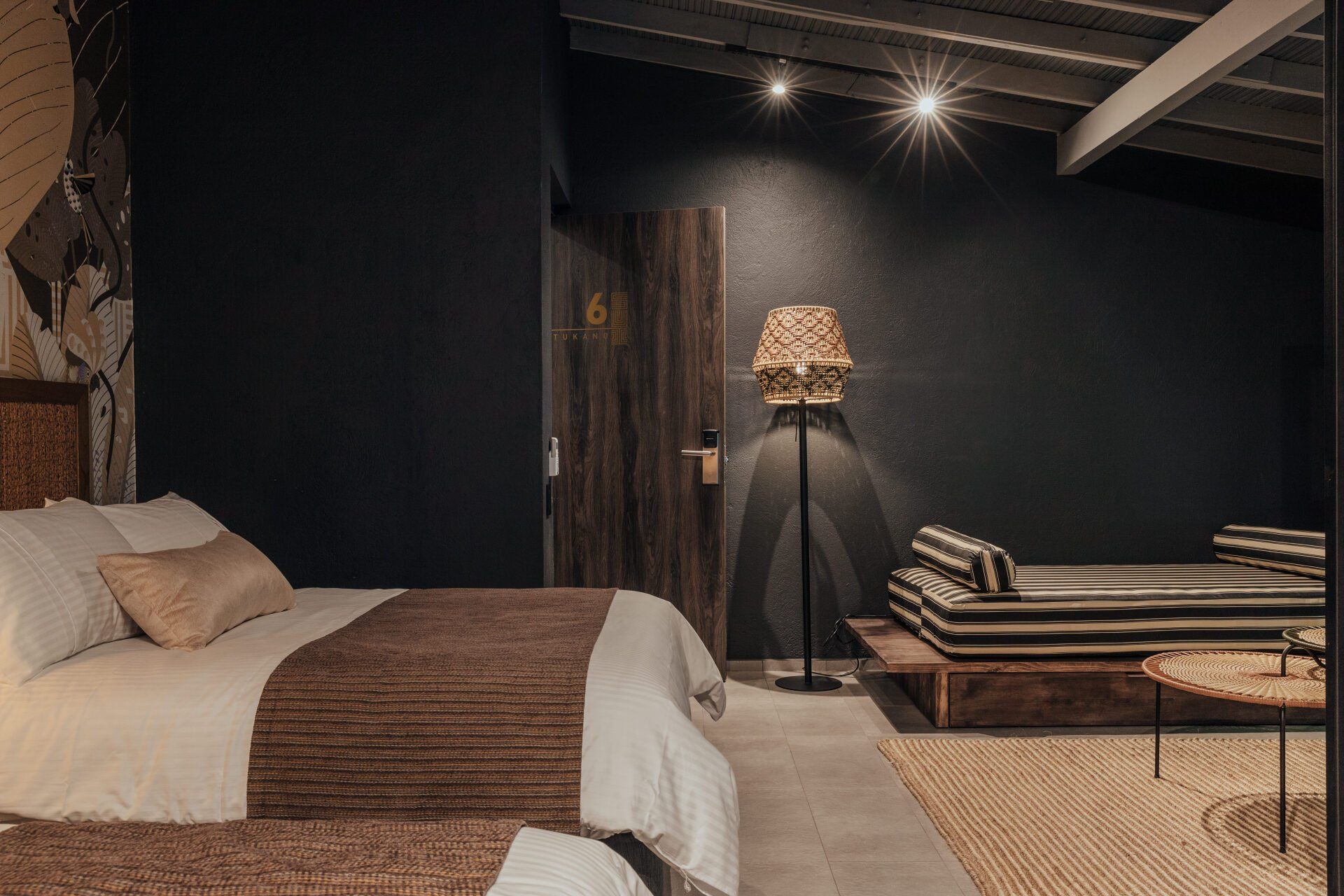 Un dormitorio con dos camas, una lámpara y un sofá.