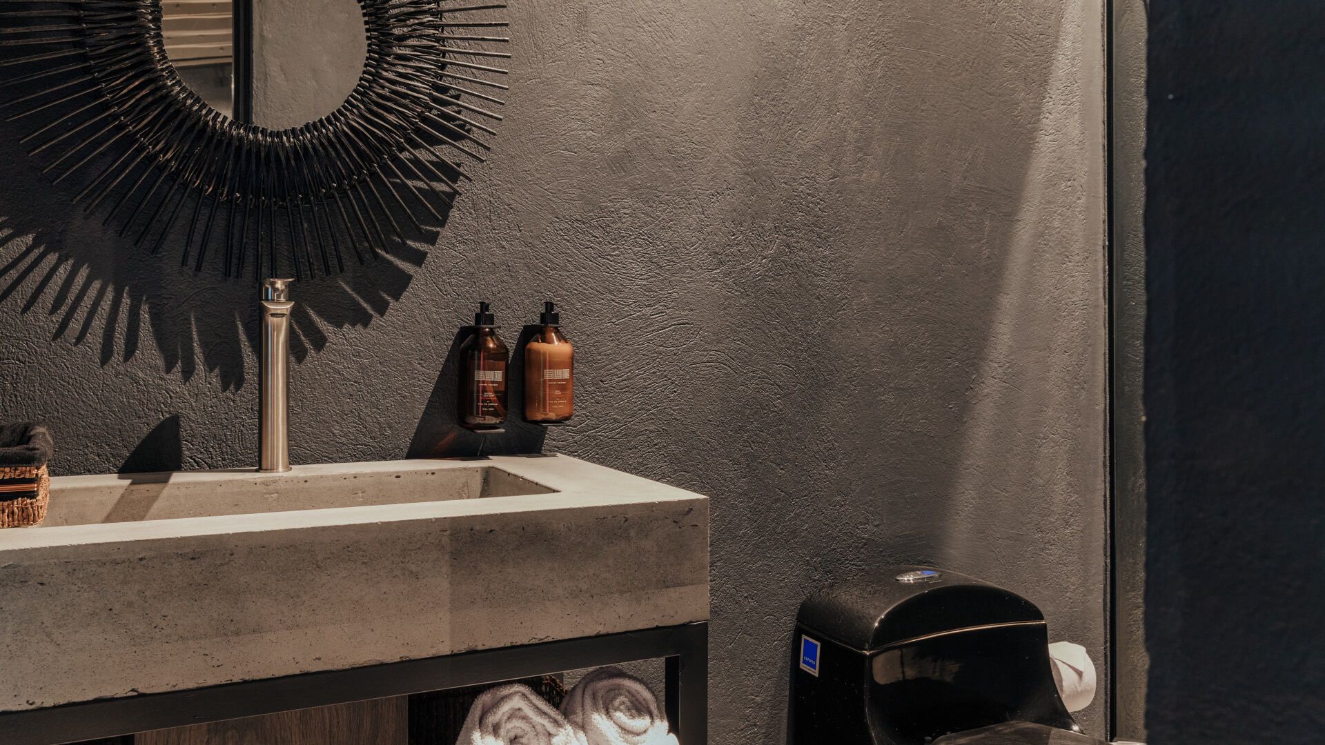 Un baño con lavabo, espejo e inodoro.