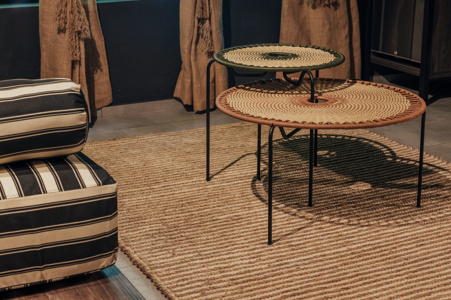 Dos mesas de mimbre están colocadas encima de una alfombra en una sala de estar.