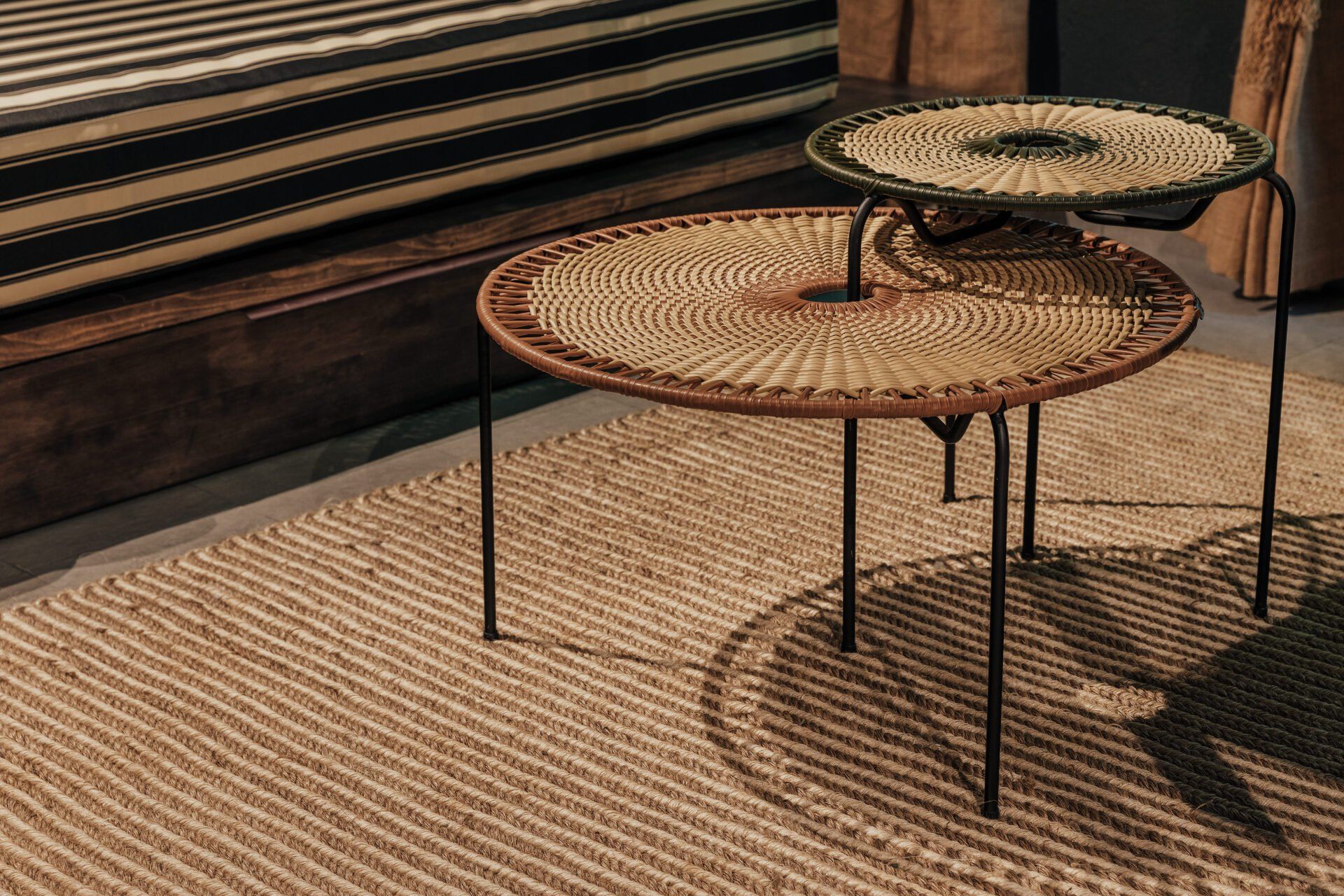 Dos mesas de mimbre están colocadas sobre una alfombra en una sala de estar.