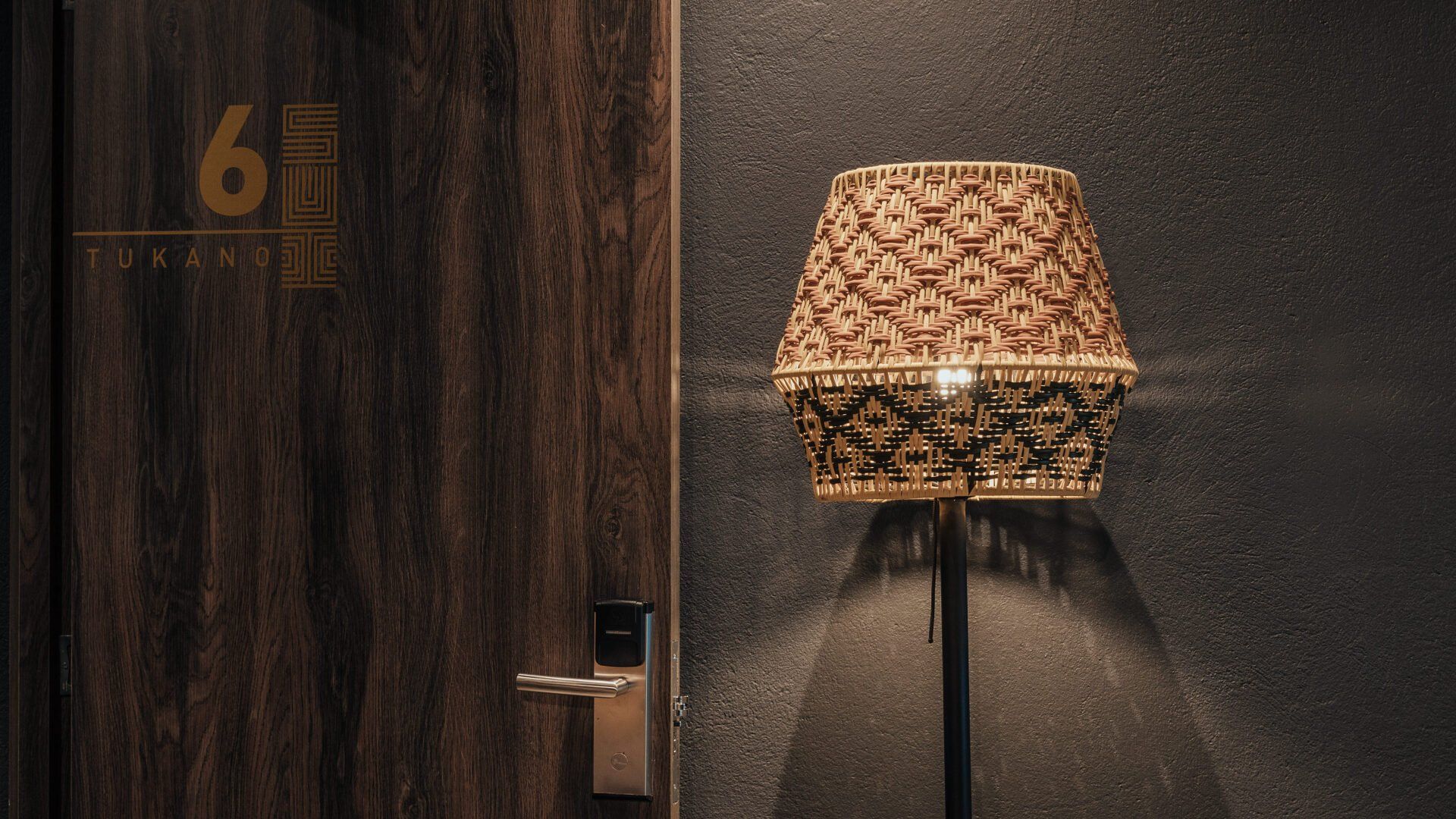 Una lámpara está delante de una puerta en una habitación de hotel.