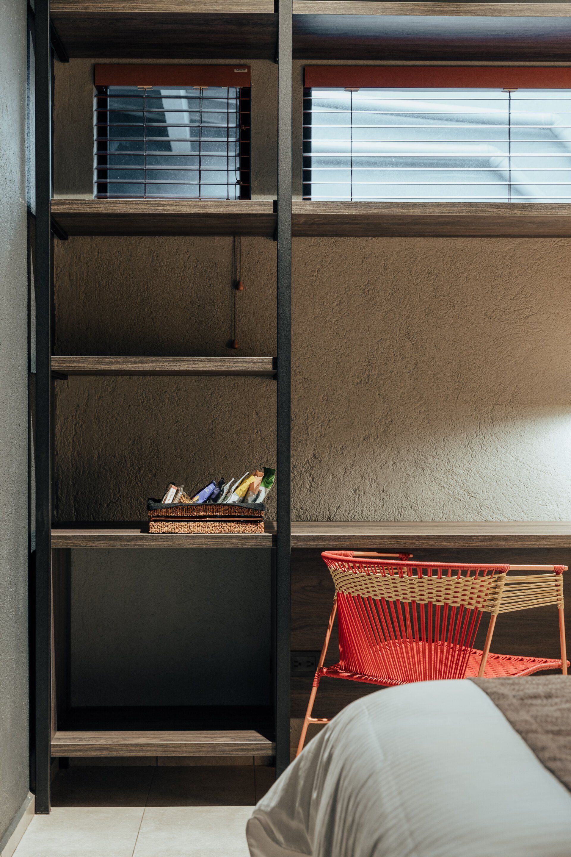 Un dormitorio con una cama, escritorio, silla y estantes.