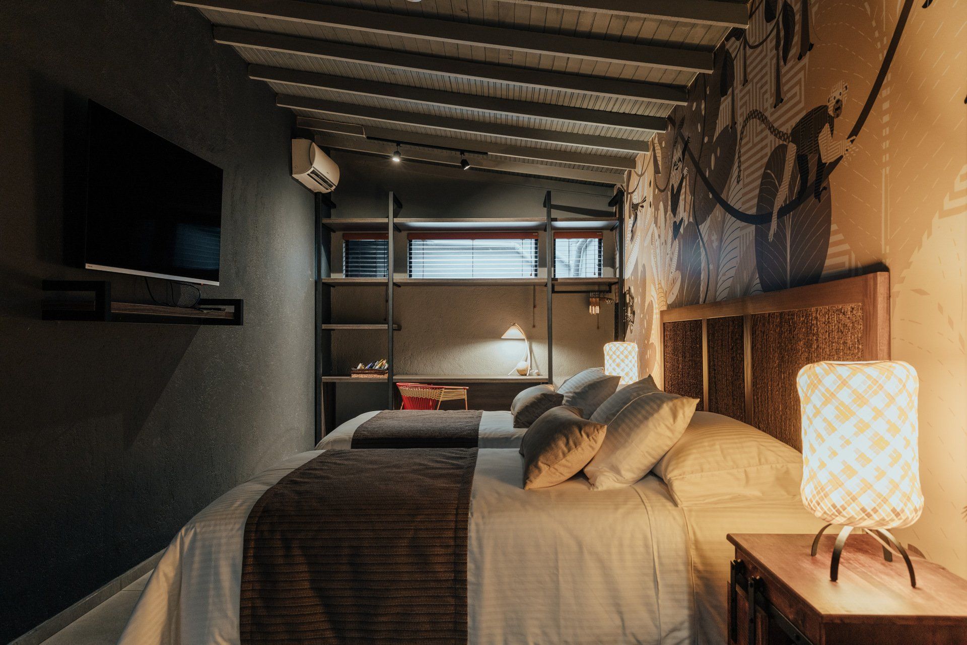 Un dormitorio con dos camas, un televisor y una lámpara.