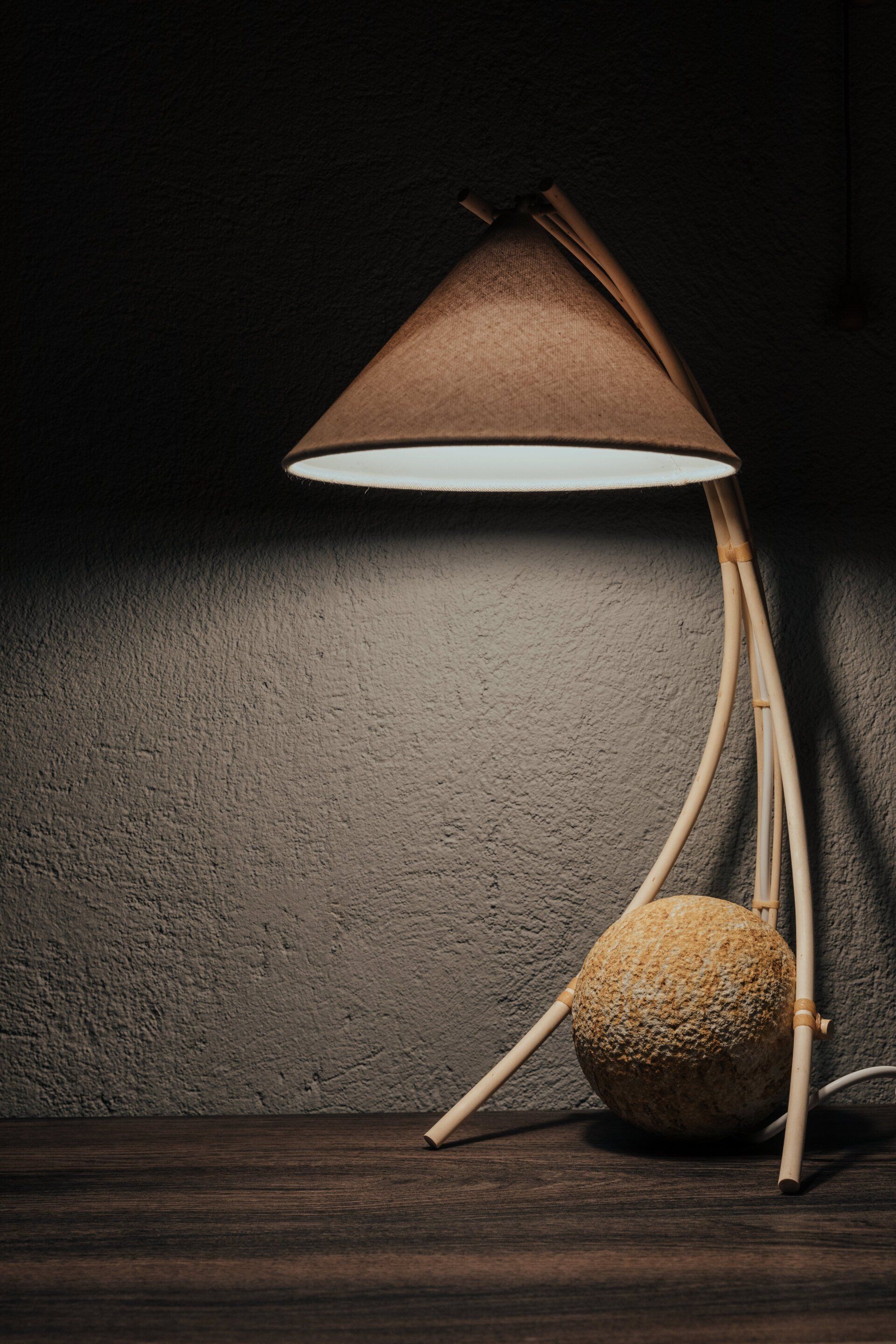 Una lámpara está sobre una mesa de madera en una habitación oscura.