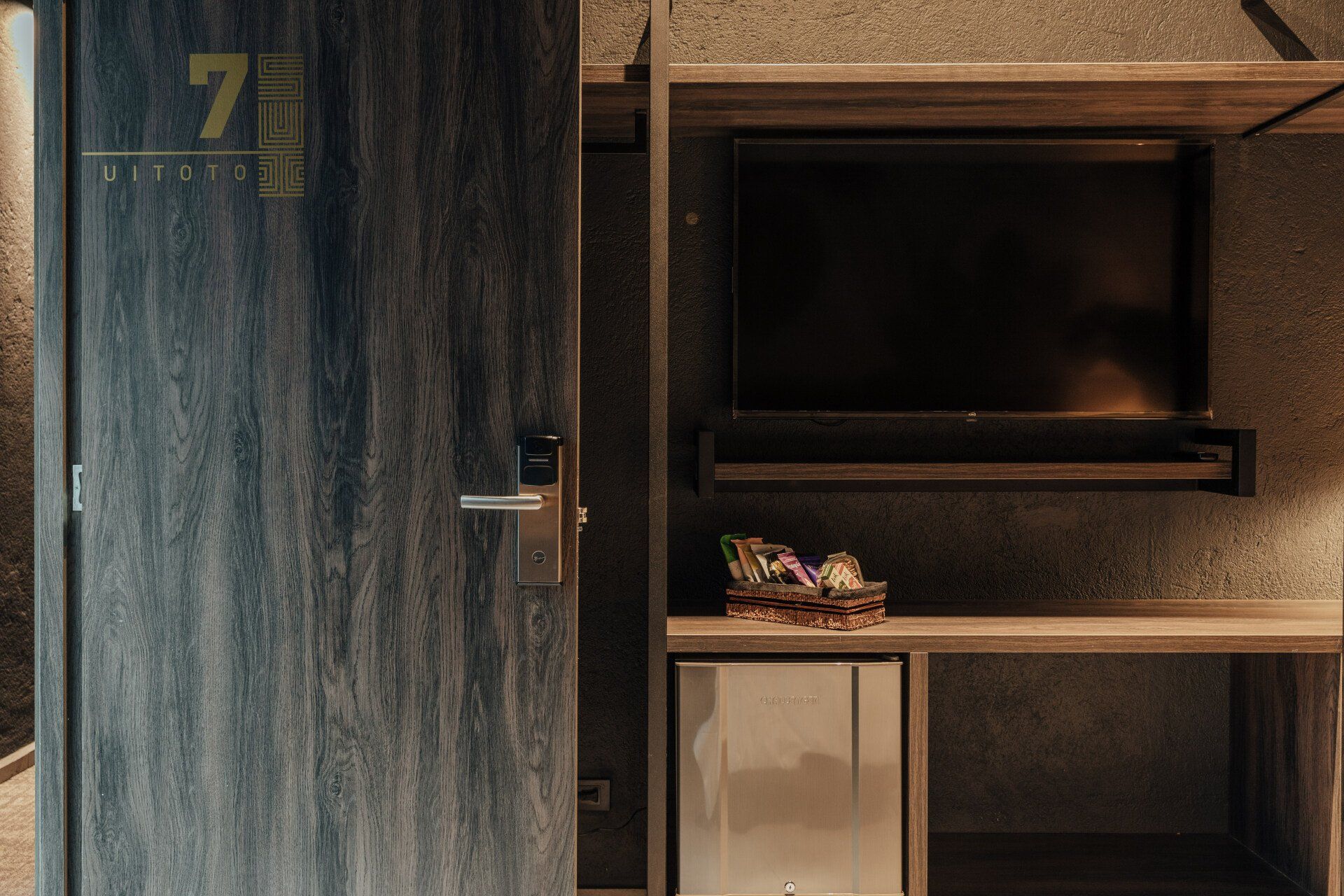 Una habitación de hotel con un televisor en la pared y un escritorio.