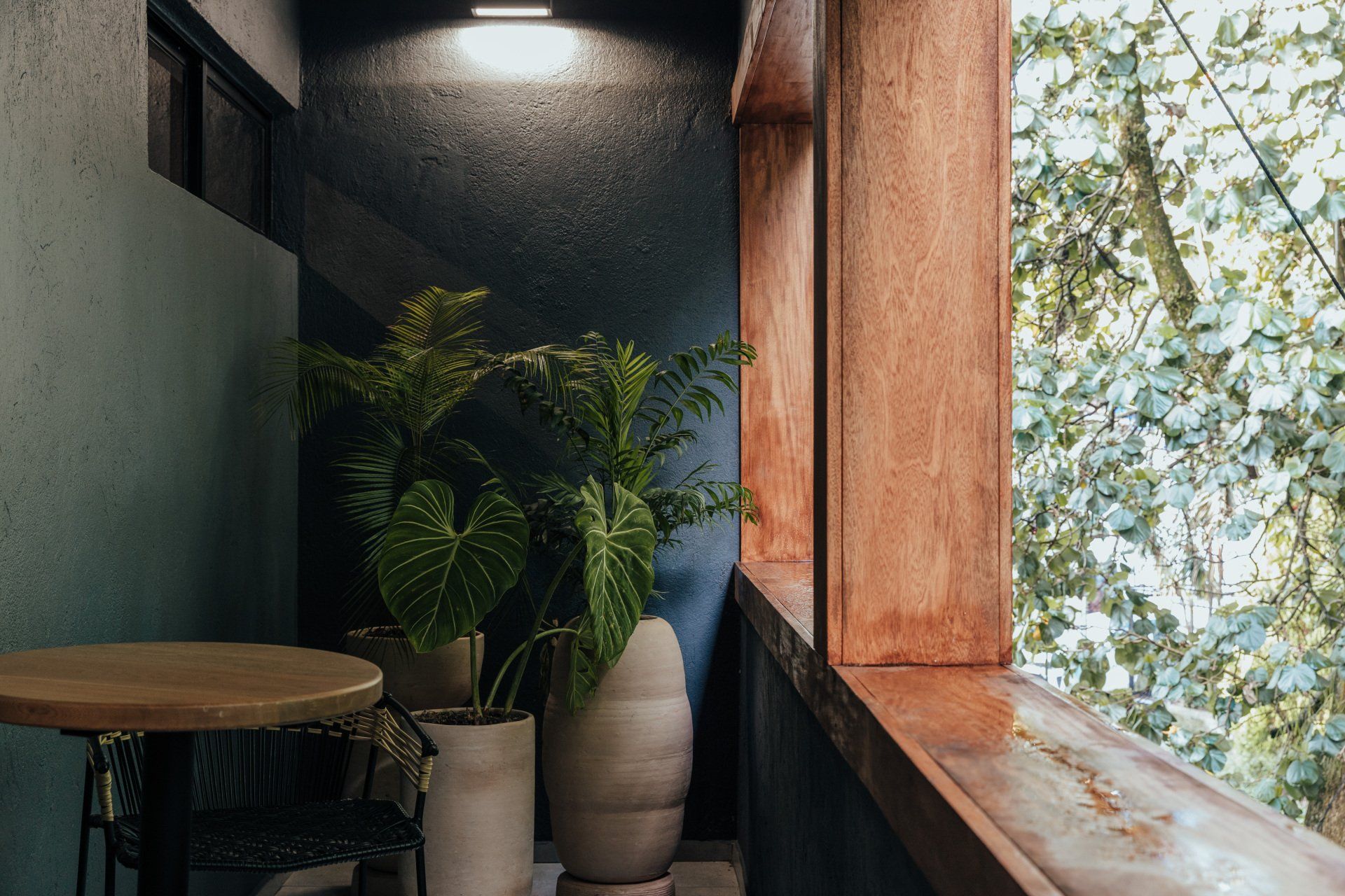 Un balcón con mesa y sillas y plantas en macetas.