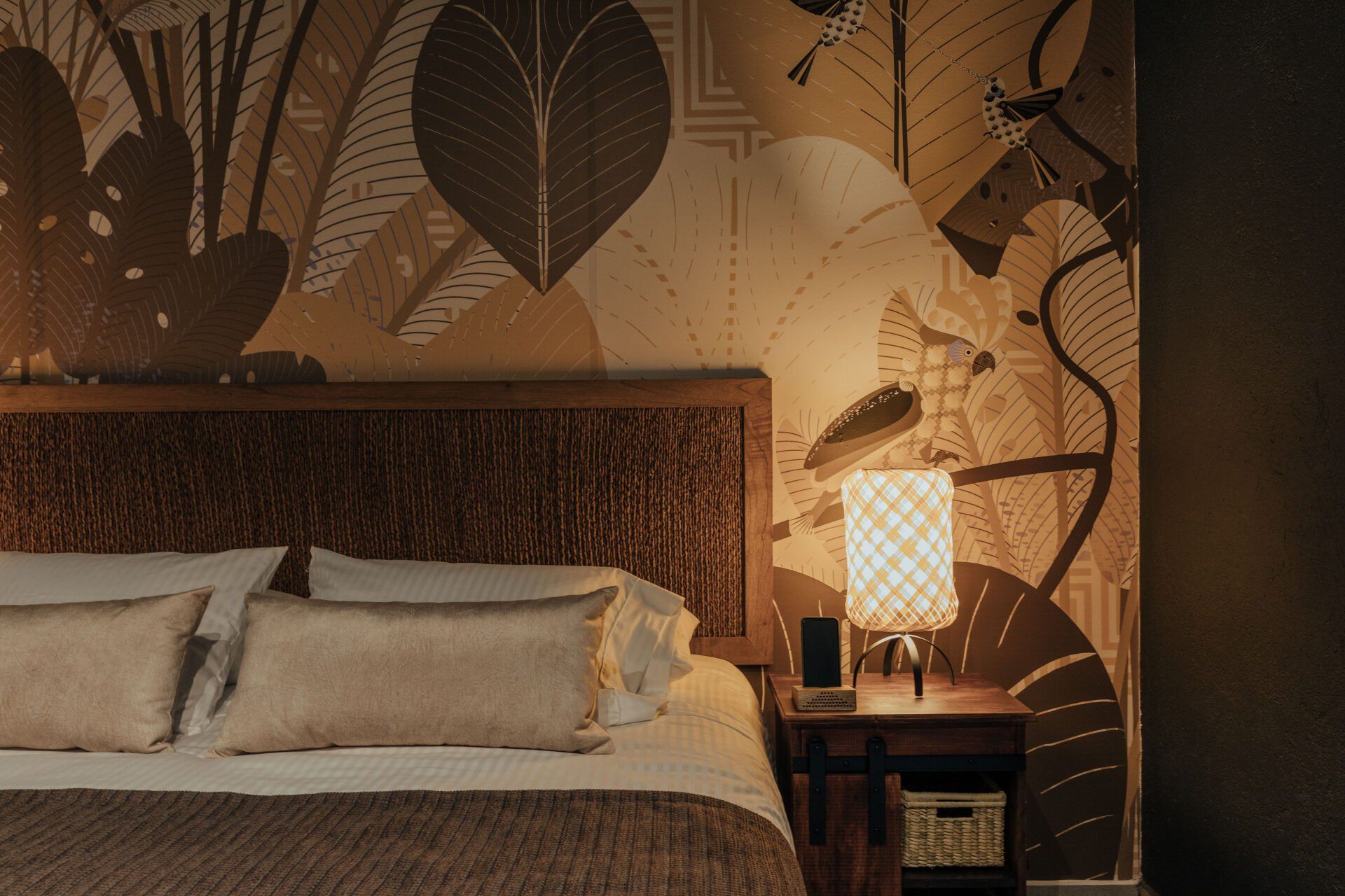 Un dormitorio con una cama, mesita de noche y lámpara.