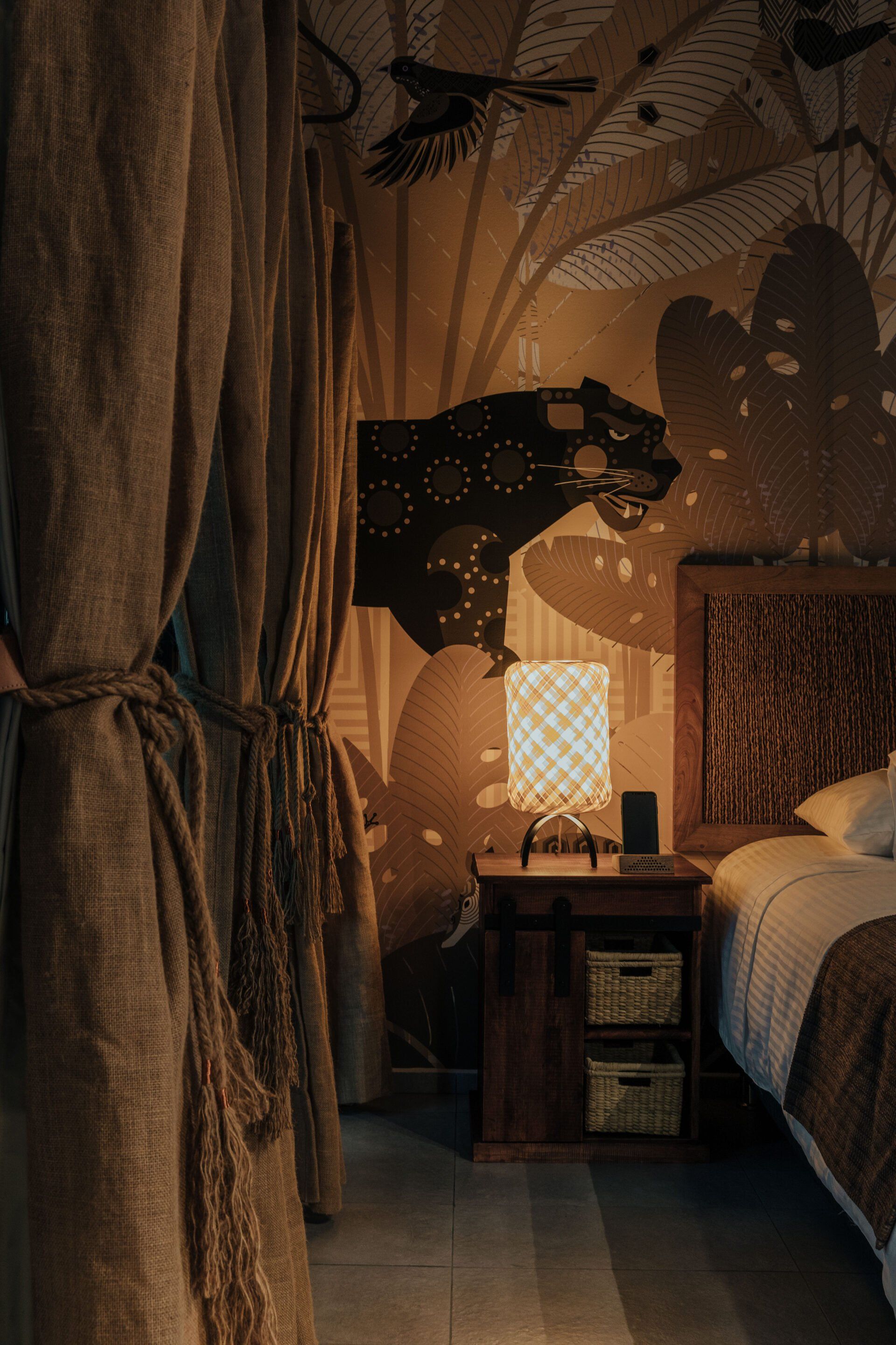 Un dormitorio con dos camas, una mesita de noche y una lámpara.