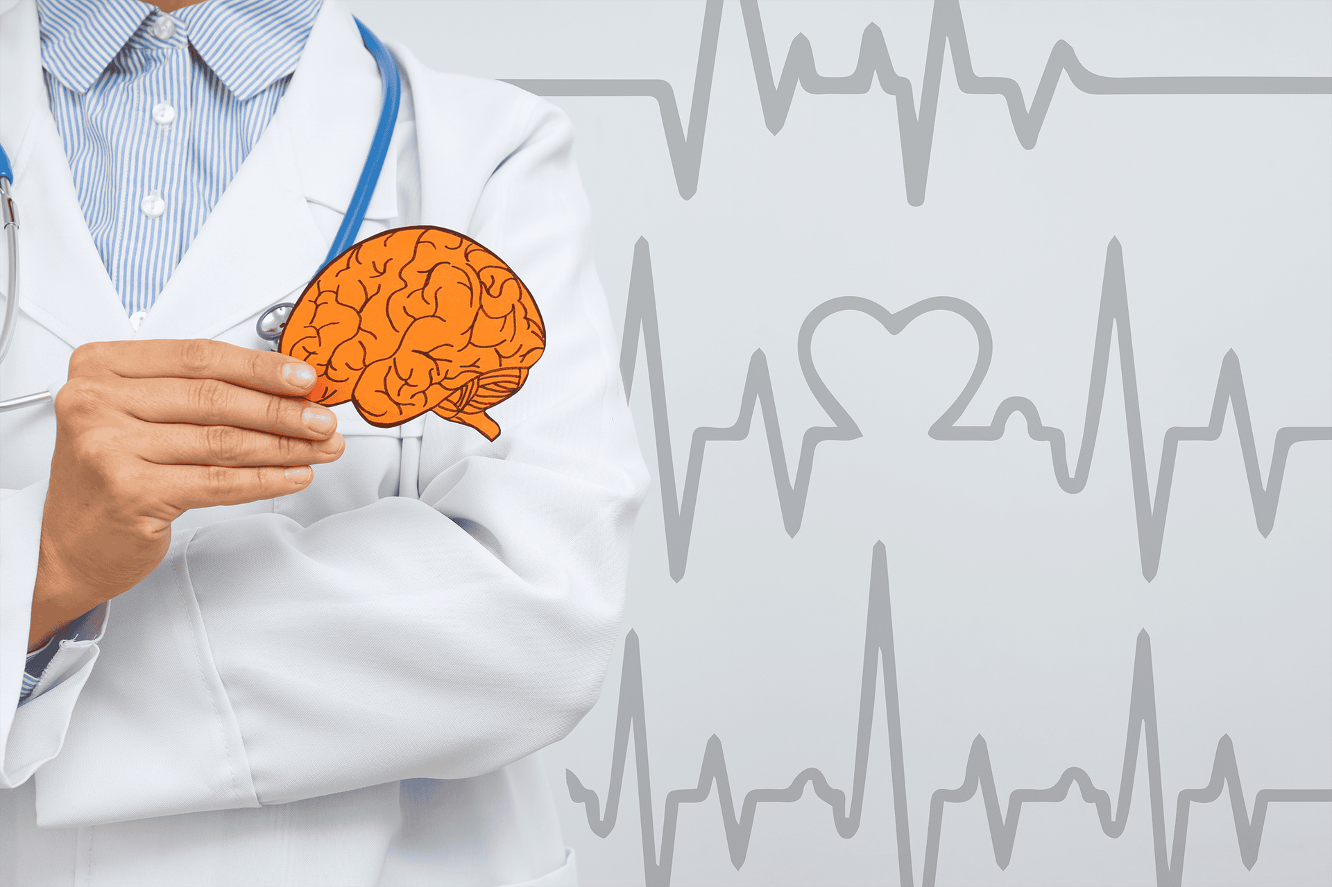 Un médico sostiene un cerebro frente a una línea de latidos del corazón.