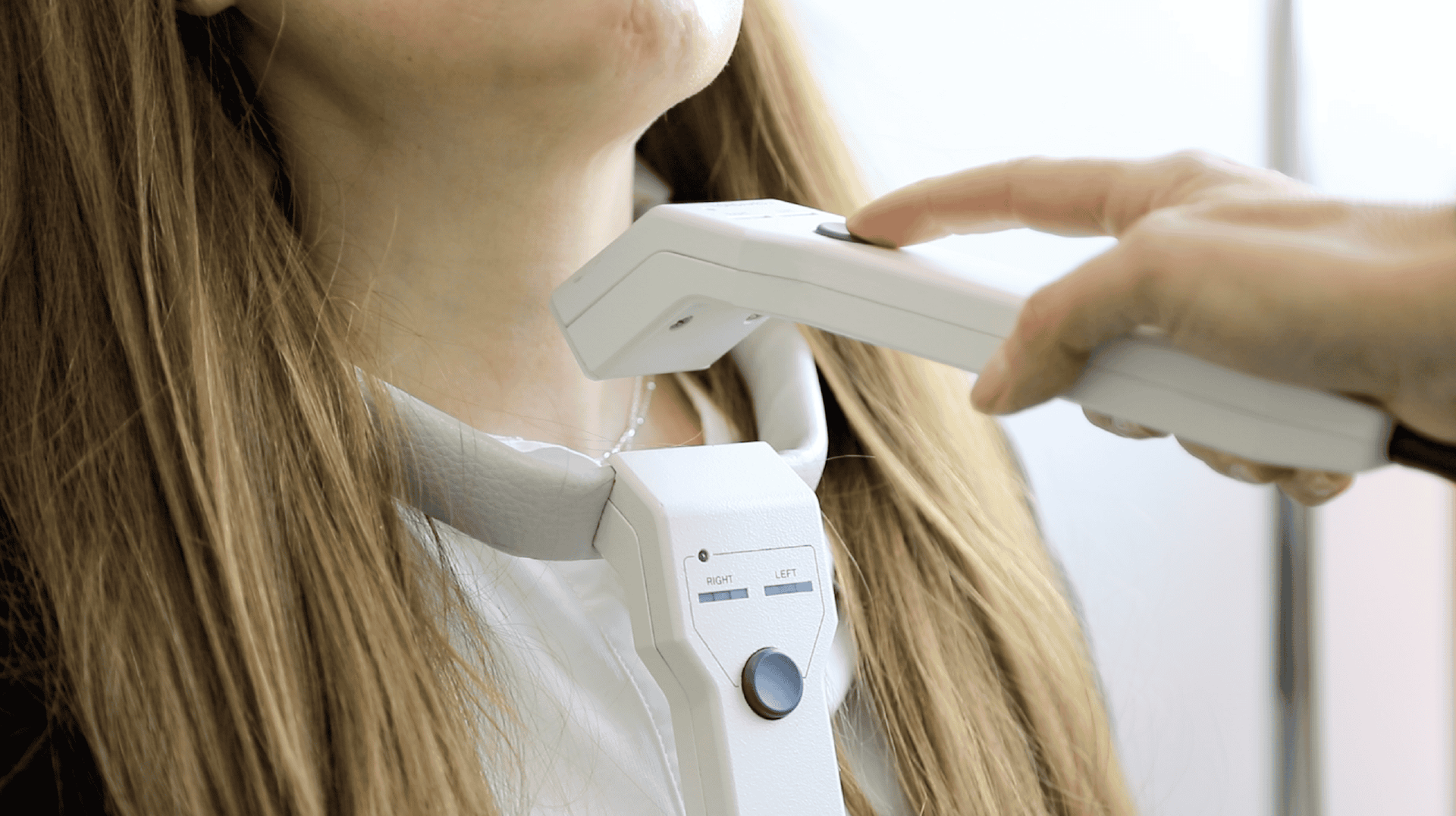 Un médico examina a una mujer con un dispositivo en el cuello.