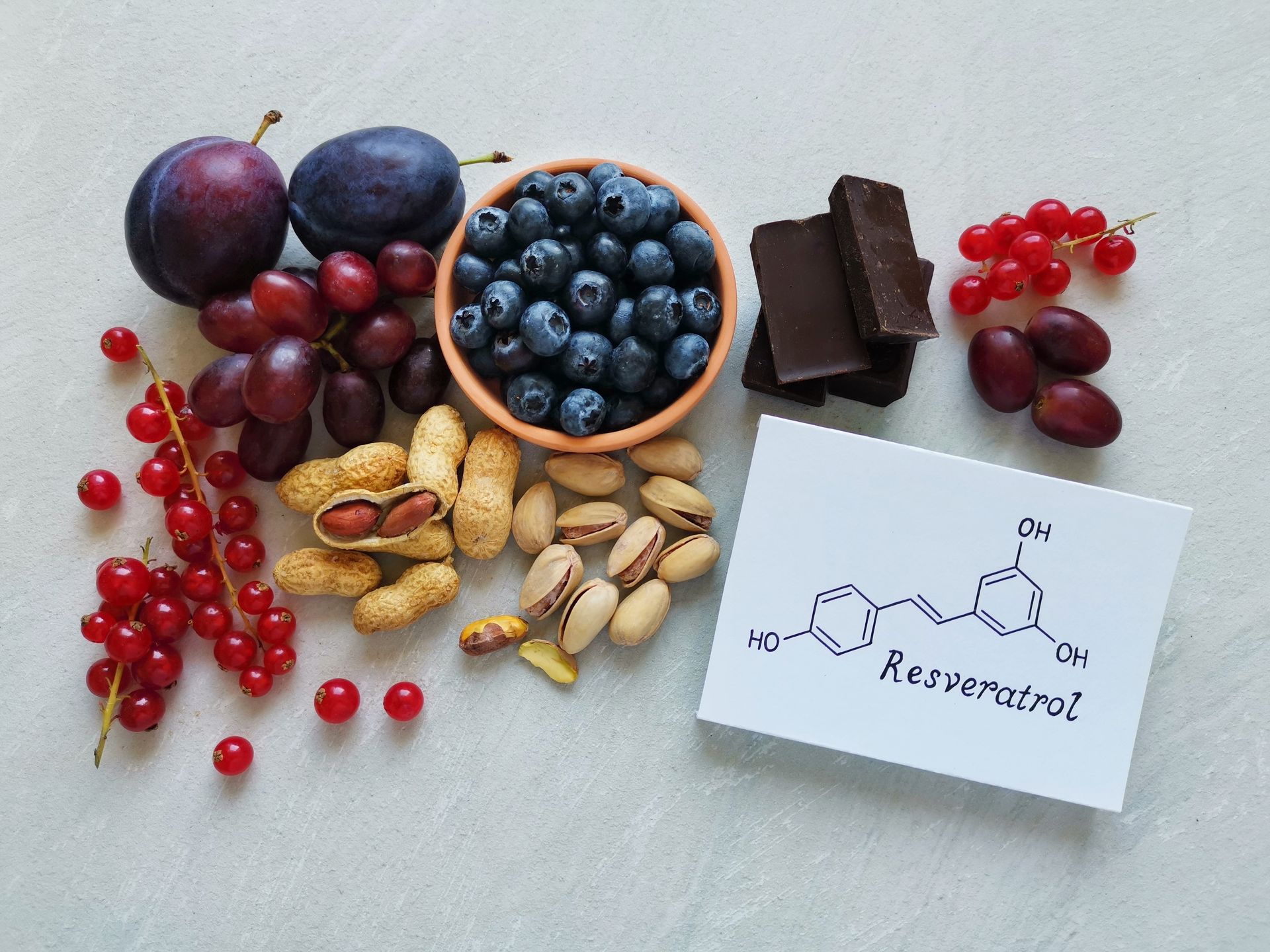 A variety of fruits , nuts , and chocolate are on a table.