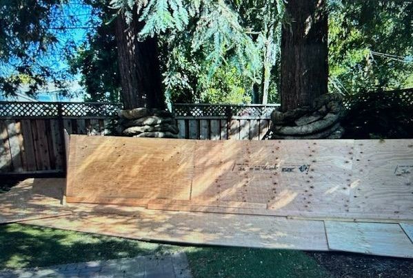 A laptop screen shows a picture of a wooden fence with trees in the background.
