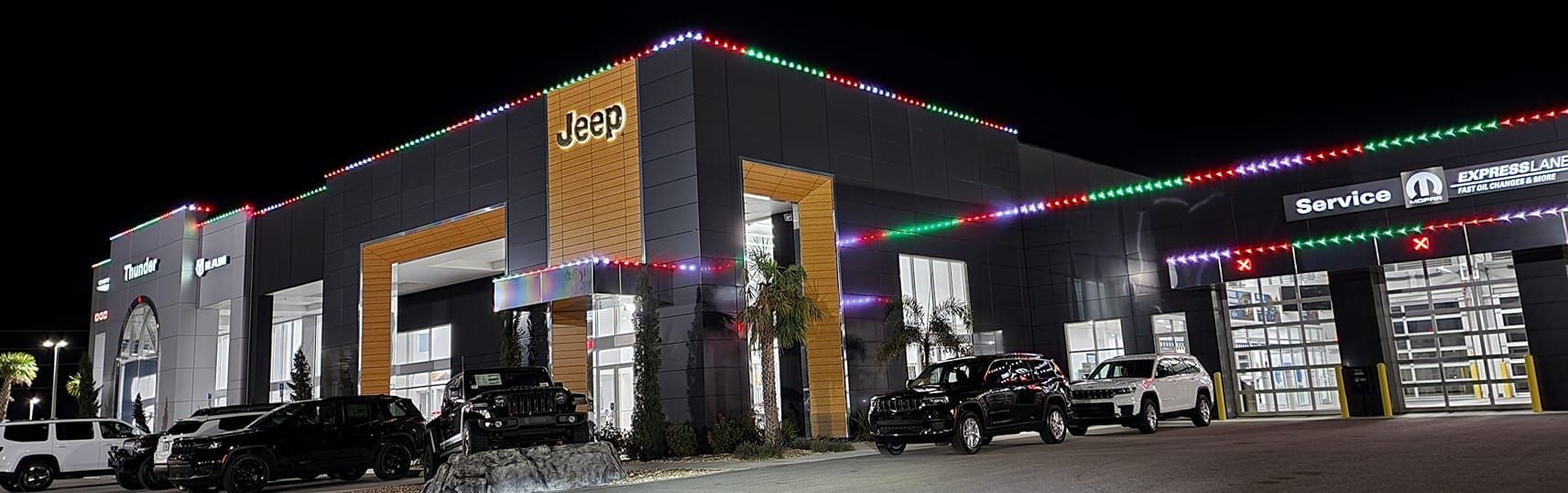 A storage building decorated with christmas lights at night.