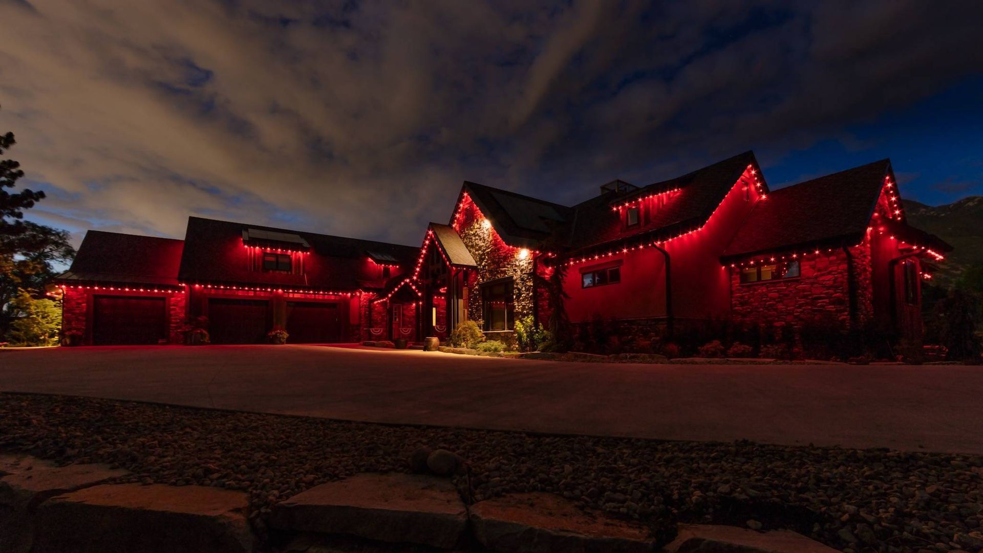 A large house is lit up with red christmas lights at night.