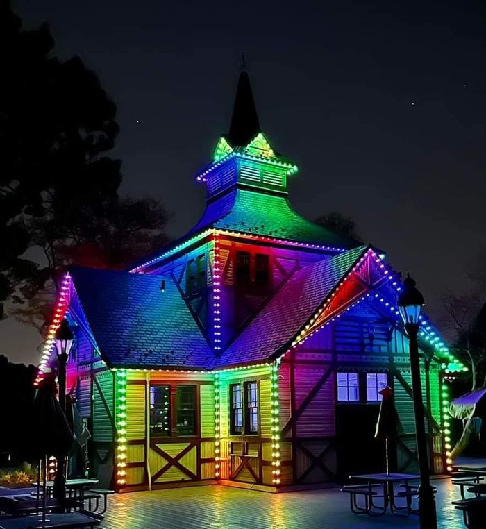 A house is lit up with rainbow lights at night