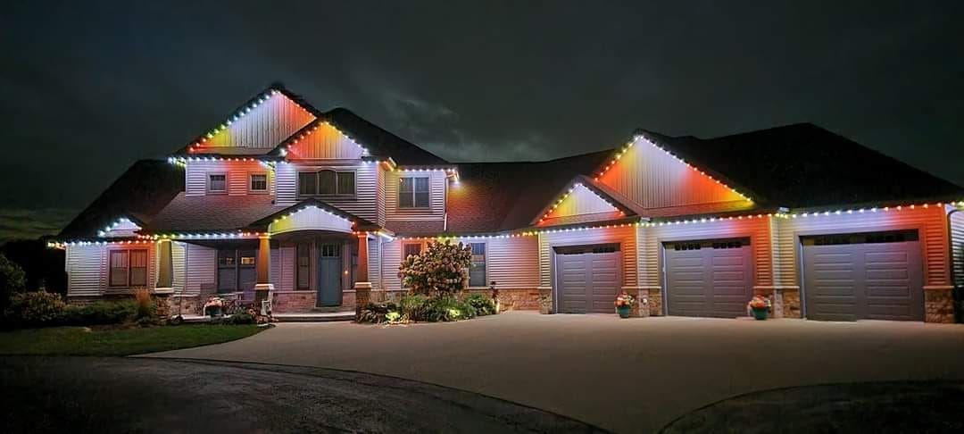 A large house is lit up with christmas lights at night.