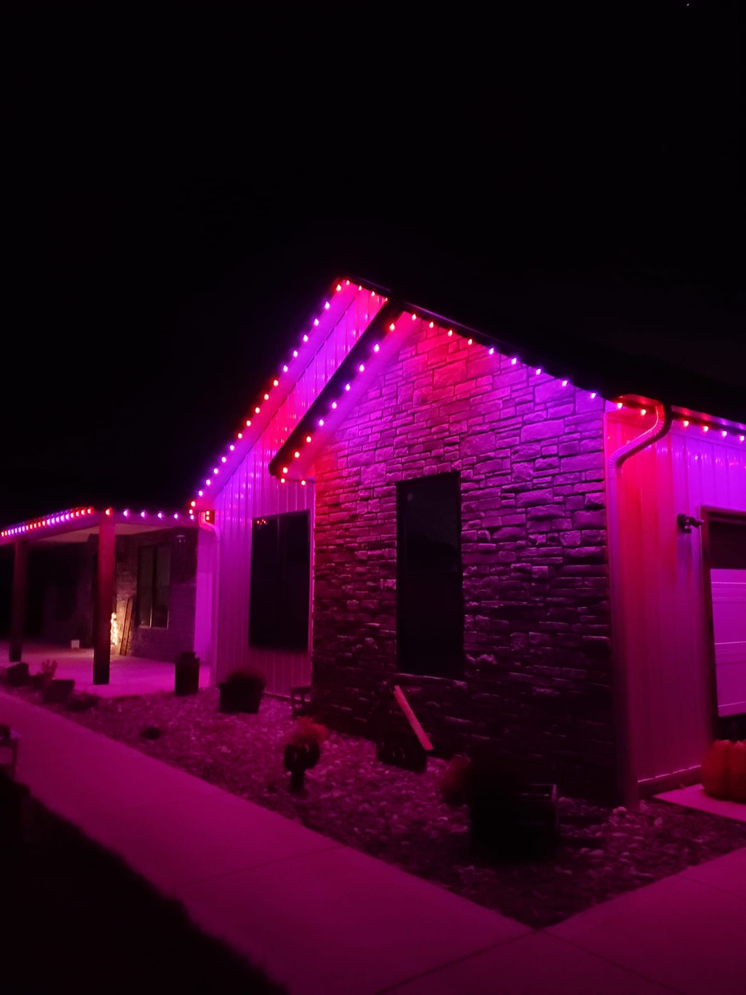 A house is lit up with purple lights at night.