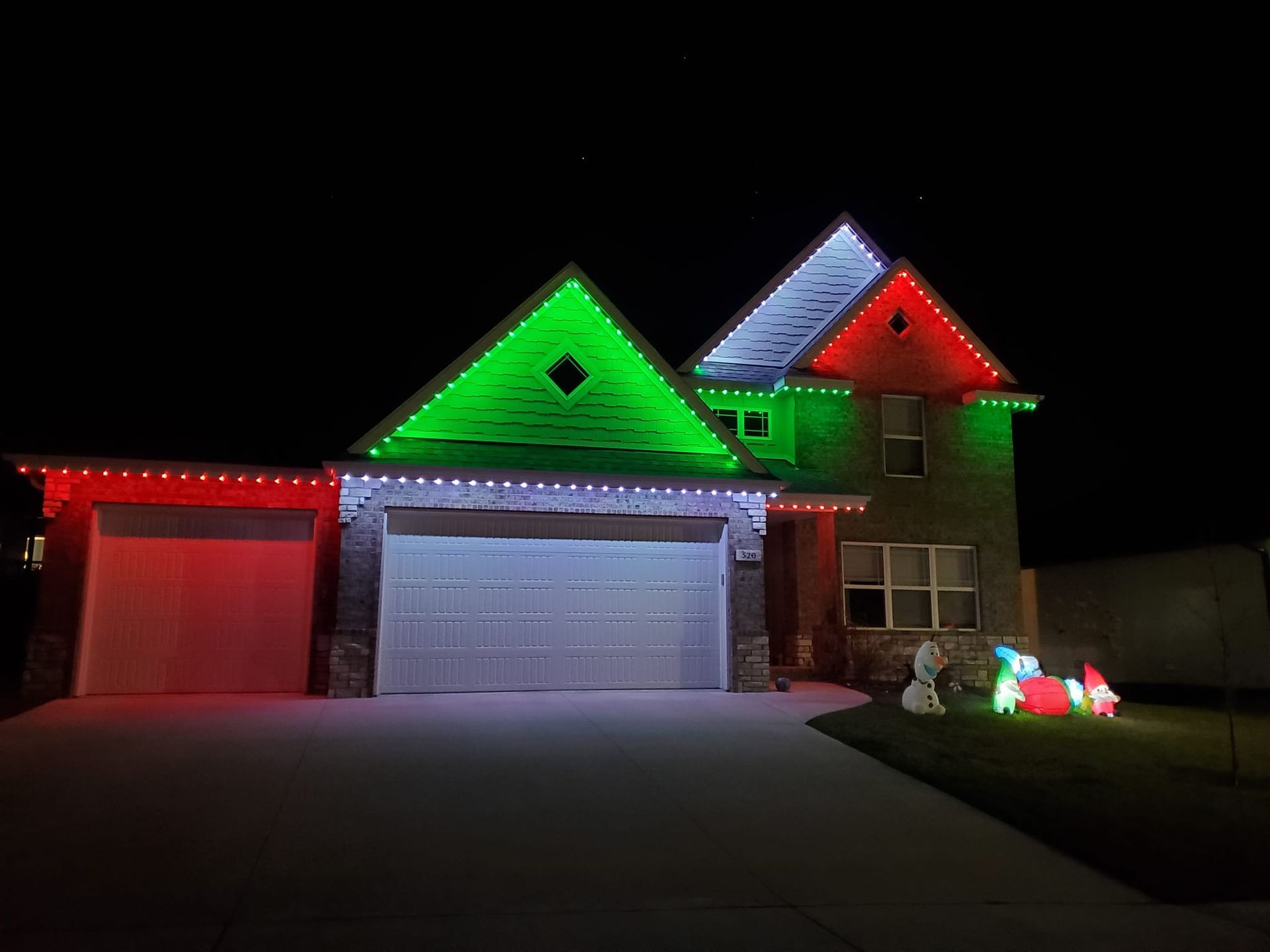A house with christmas lights on it at night.