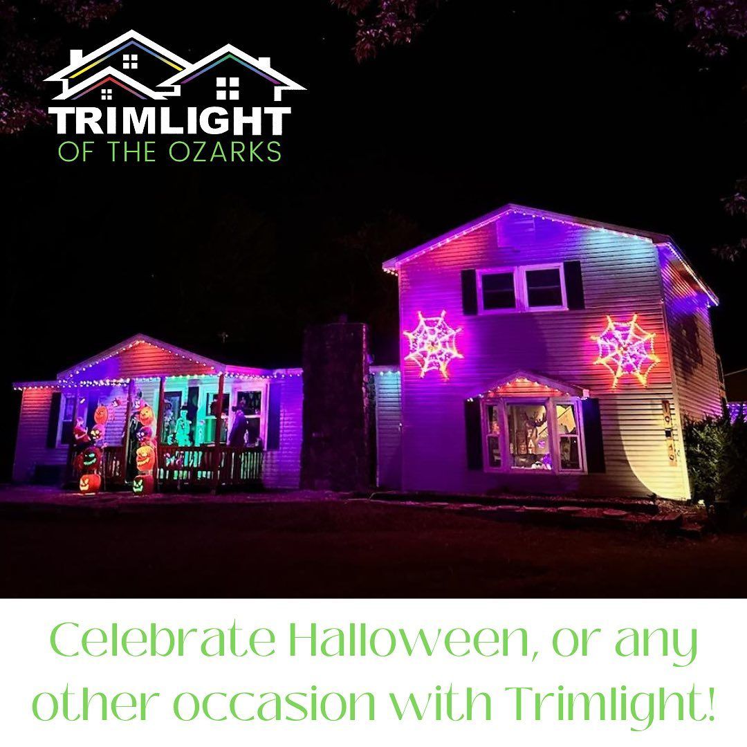 A house is decorated for halloween with purple lights and snowflakes.