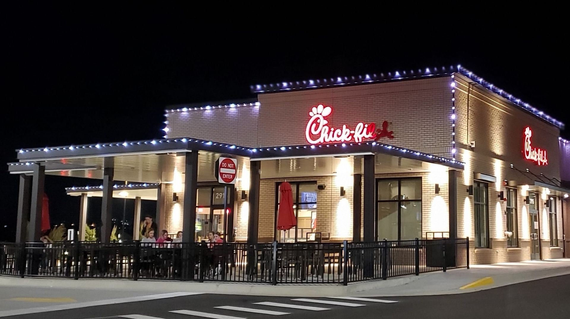 A chick fil a restaurant is lit up at night.