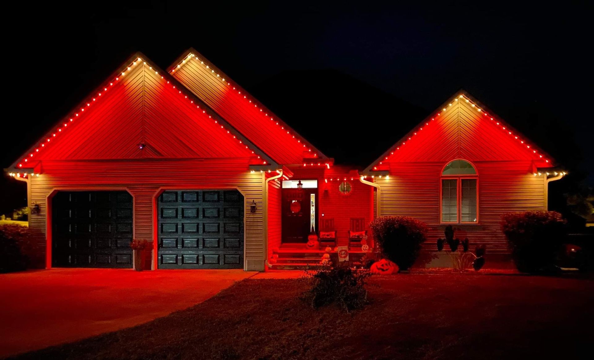 A house is lit up with red lights at night.