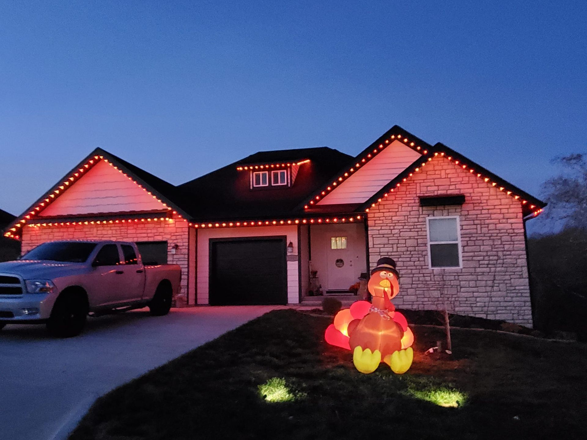 A white truck is parked in front of a house decorated for halloween