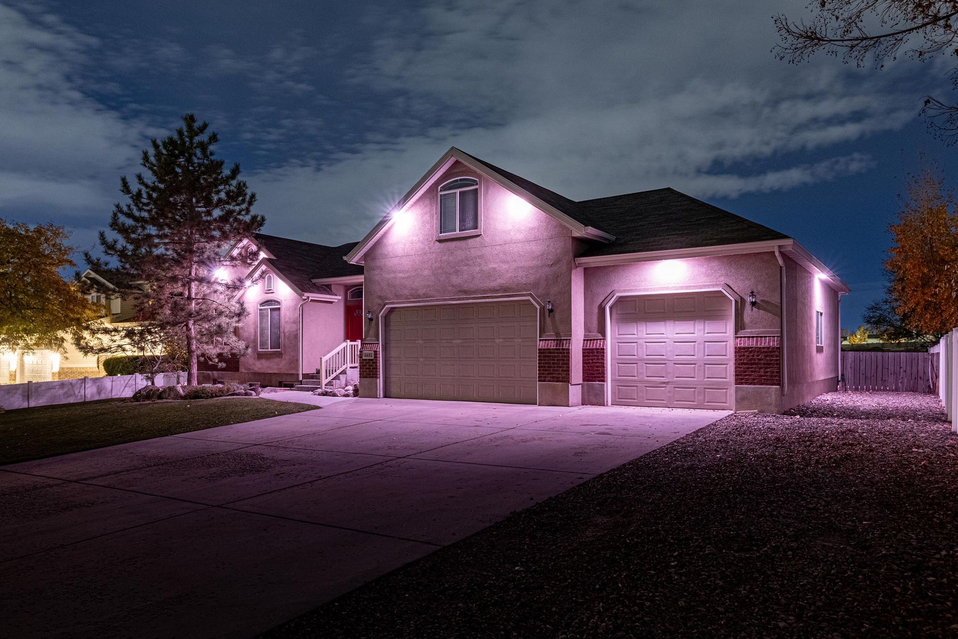 A house with pink lights on it is lit up at night.