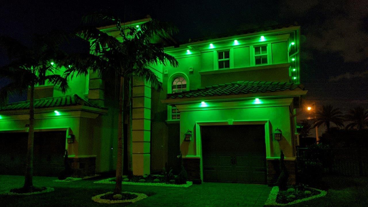 A house is lit up with green lights at night.