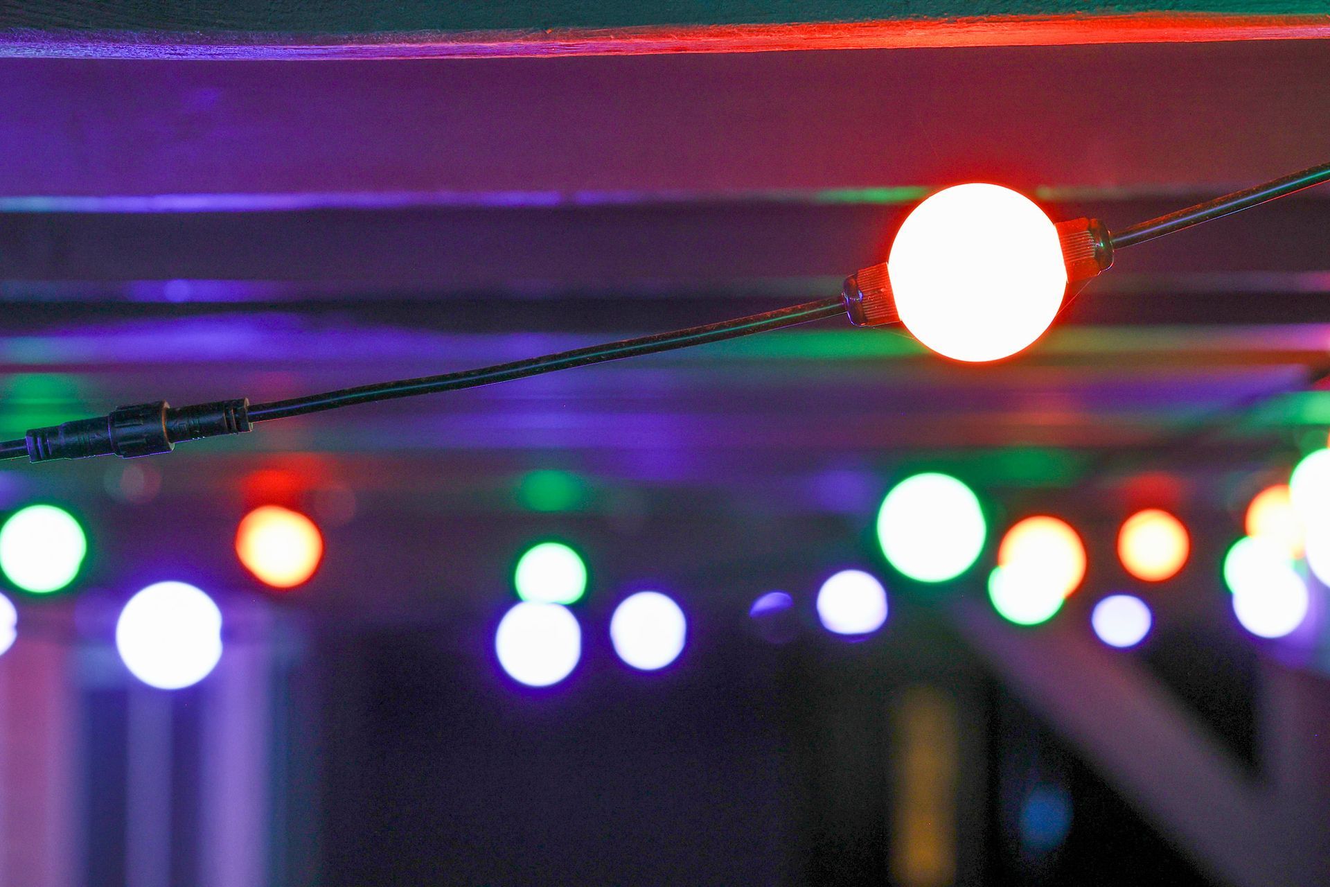 A bunch of colorful lights are hanging from the ceiling