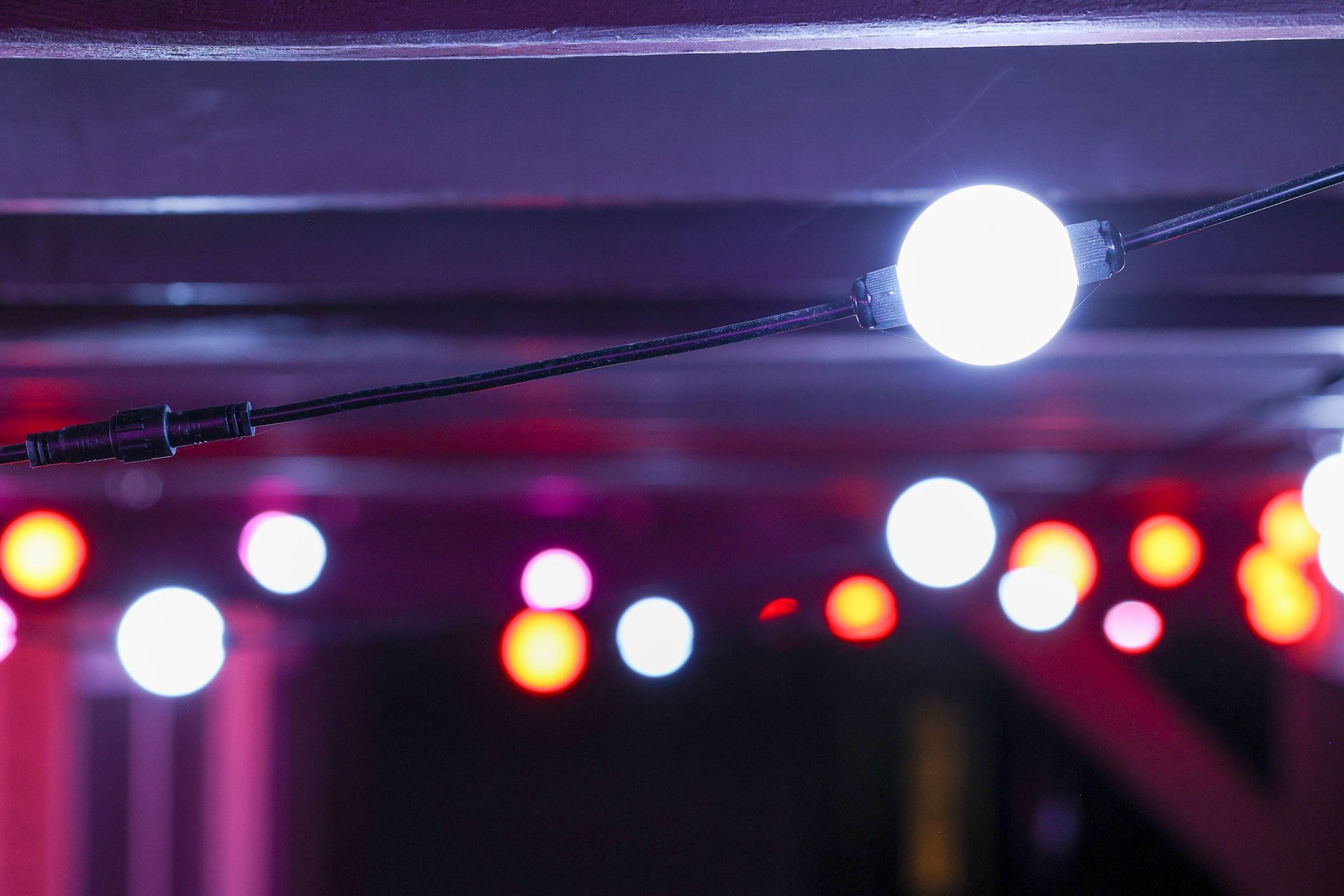 A string of lights is hanging from the ceiling in a dark room.
