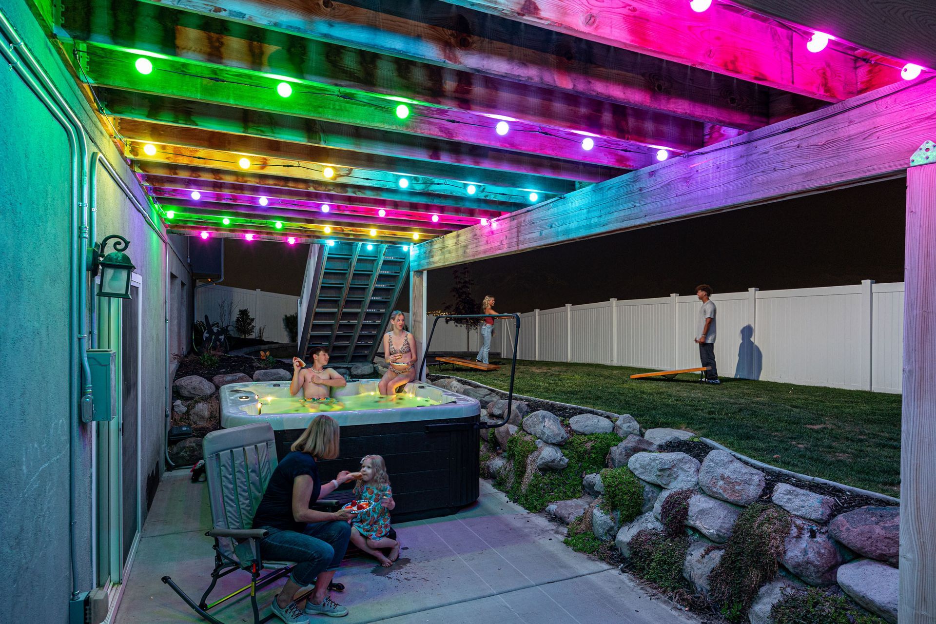 A group of people are playing in a hot tub on a patio.