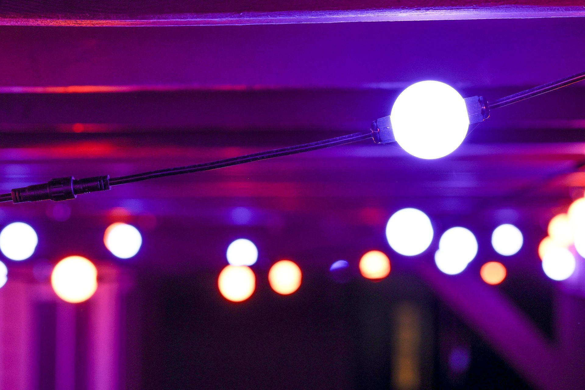 A string of lights is hanging from the ceiling in a dark room.