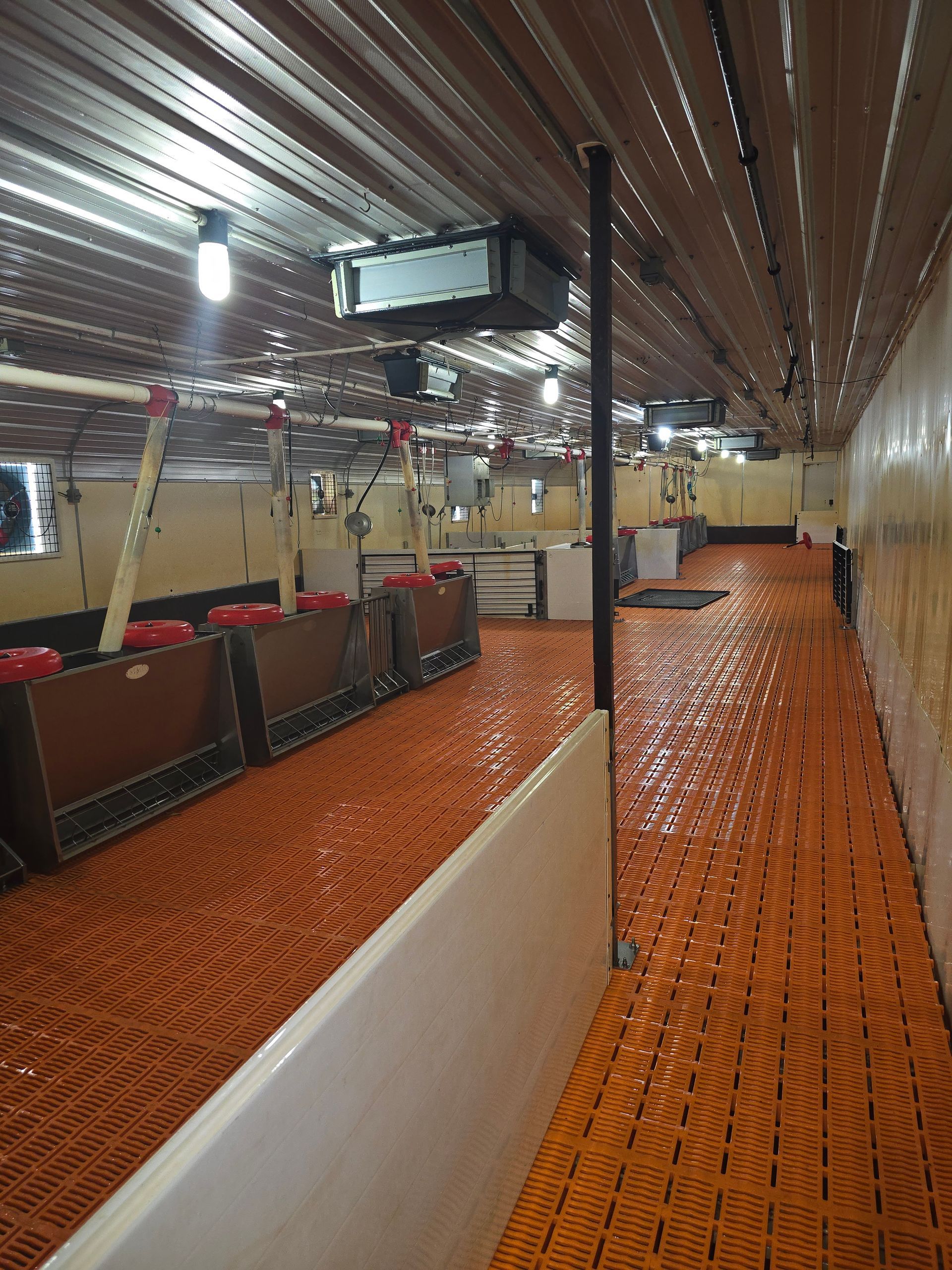 A long hallway in a building with orange floors and walls.
